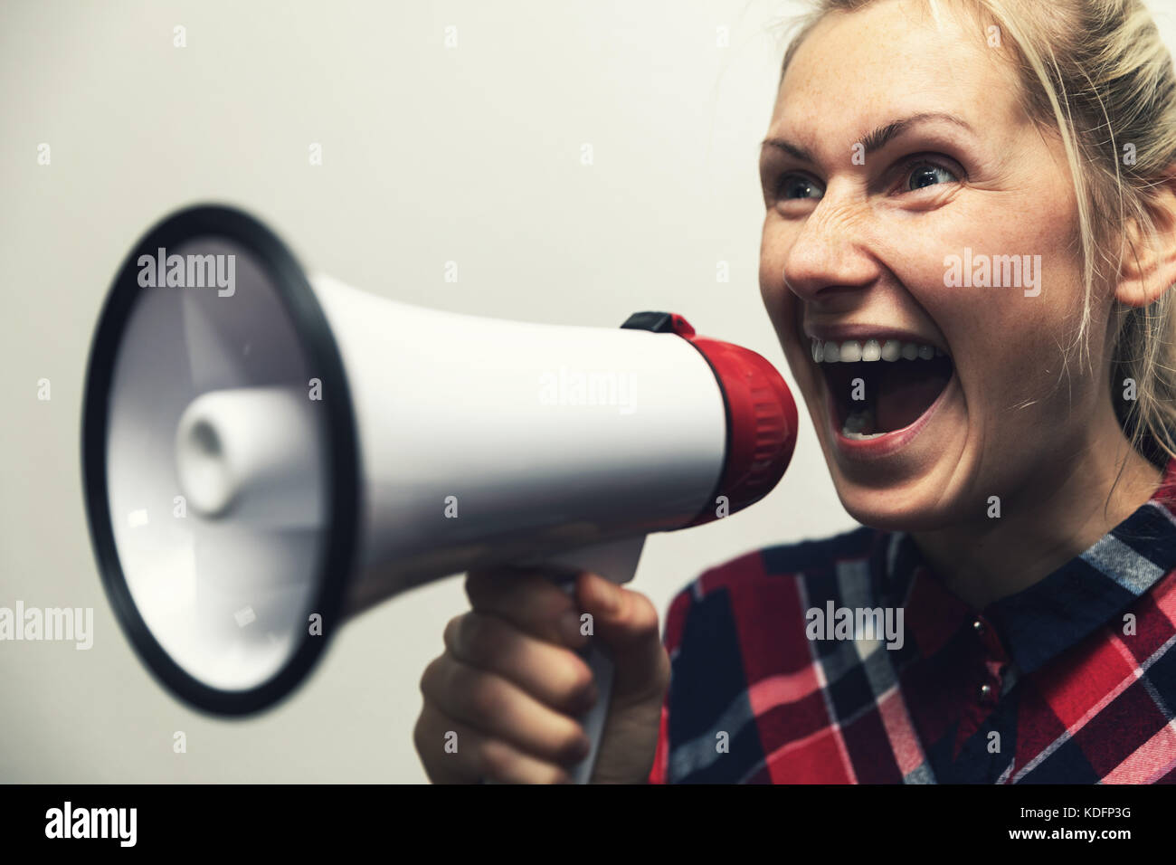 Arrabbiato grida donna con megafono in mano Foto Stock