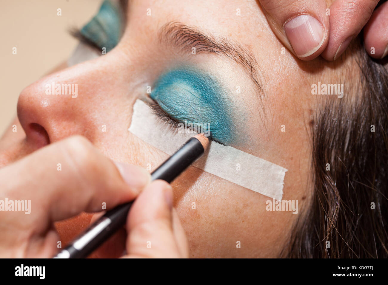 Make up Artist usando del nastro adesivo protettivo per la creazione di occhi di gatto Foto Stock