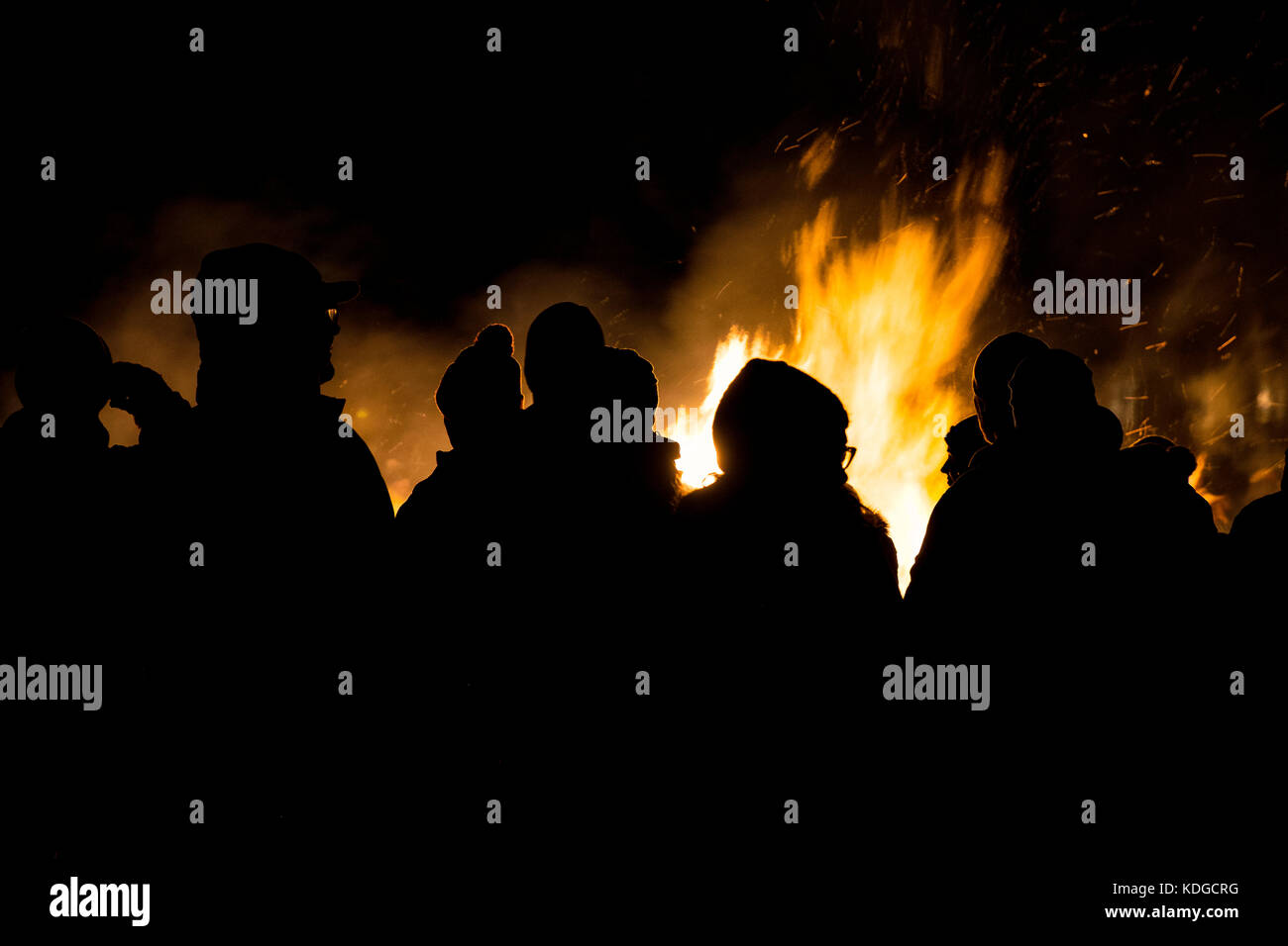 Persone silhouttes contro un falò di notte Foto Stock