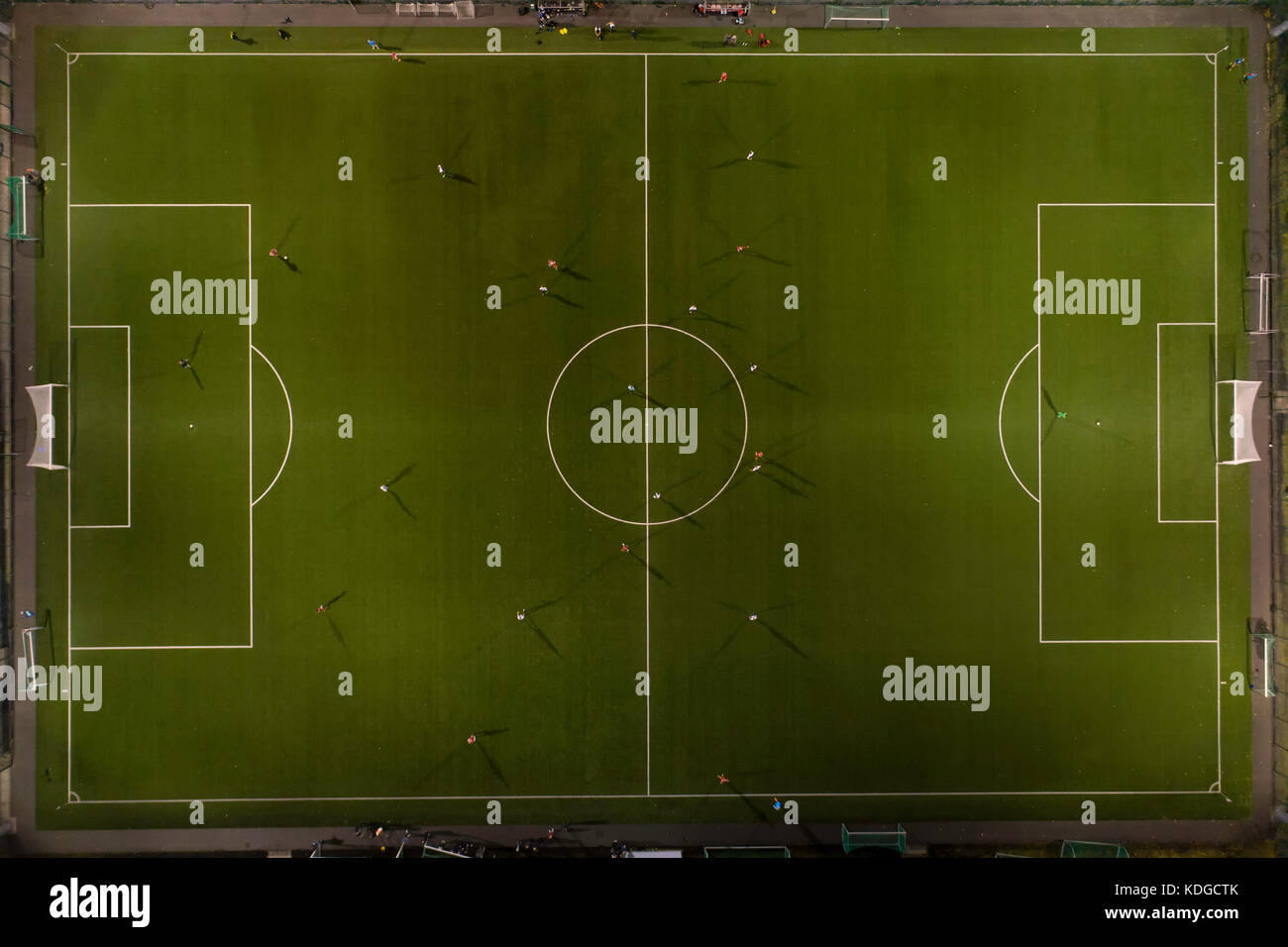 Il calcio giocato nelle ore notturne, giocatori sul campo e fari di illuminazione del passo Foto Stock