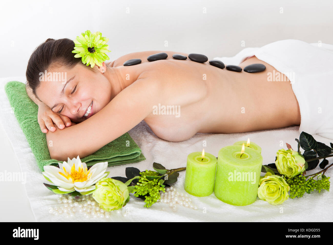 Giovane donna felice getting hot stone massage nella spa Foto Stock