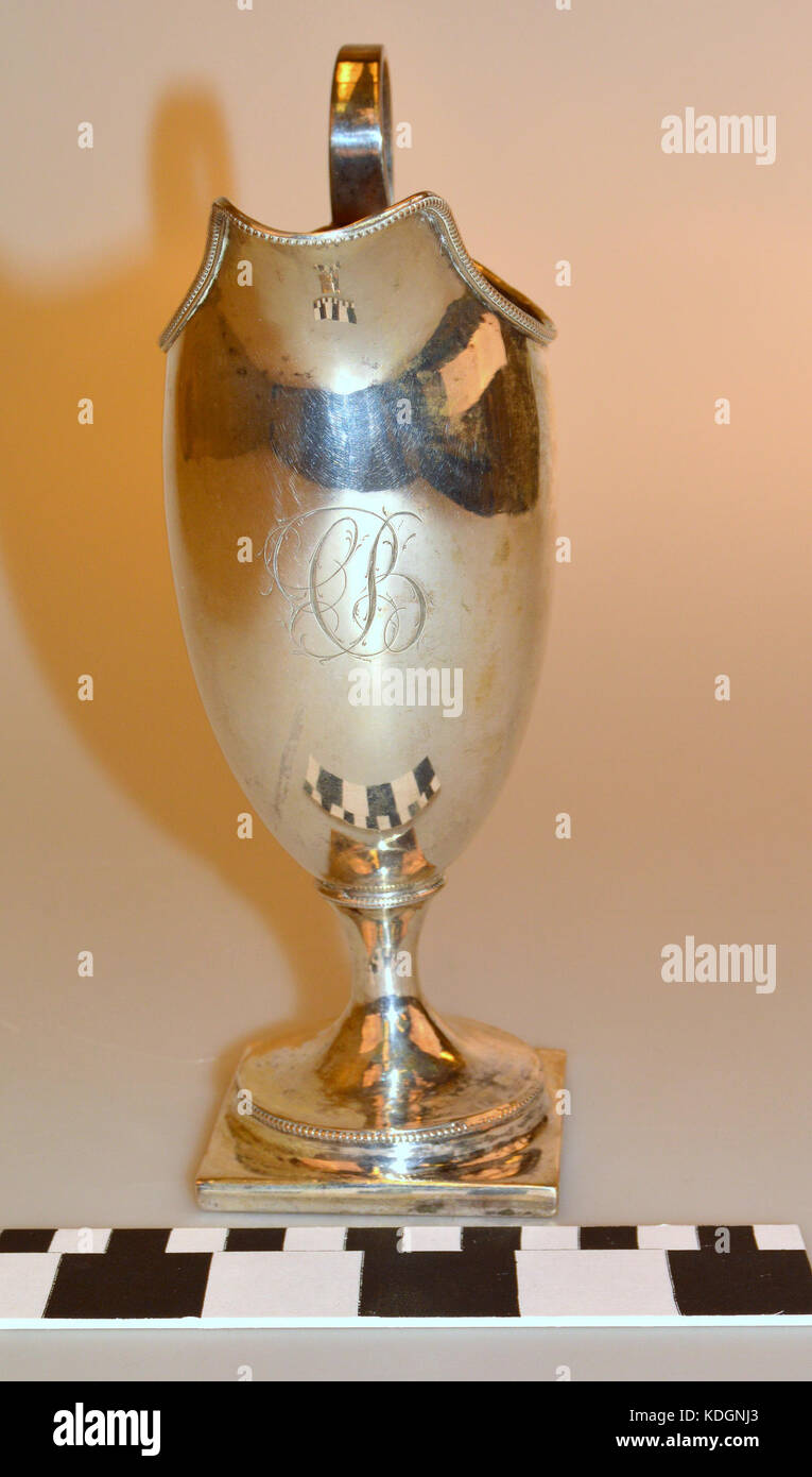 Questa caraffa color crema d'argento è un ottimo esempio di artigianato antico. Il design e i materiali delicati sottolineano l'eleganza delle stoviglie del XIX secolo, offrendo uno sguardo ai valori estetici del tempo. Foto Stock