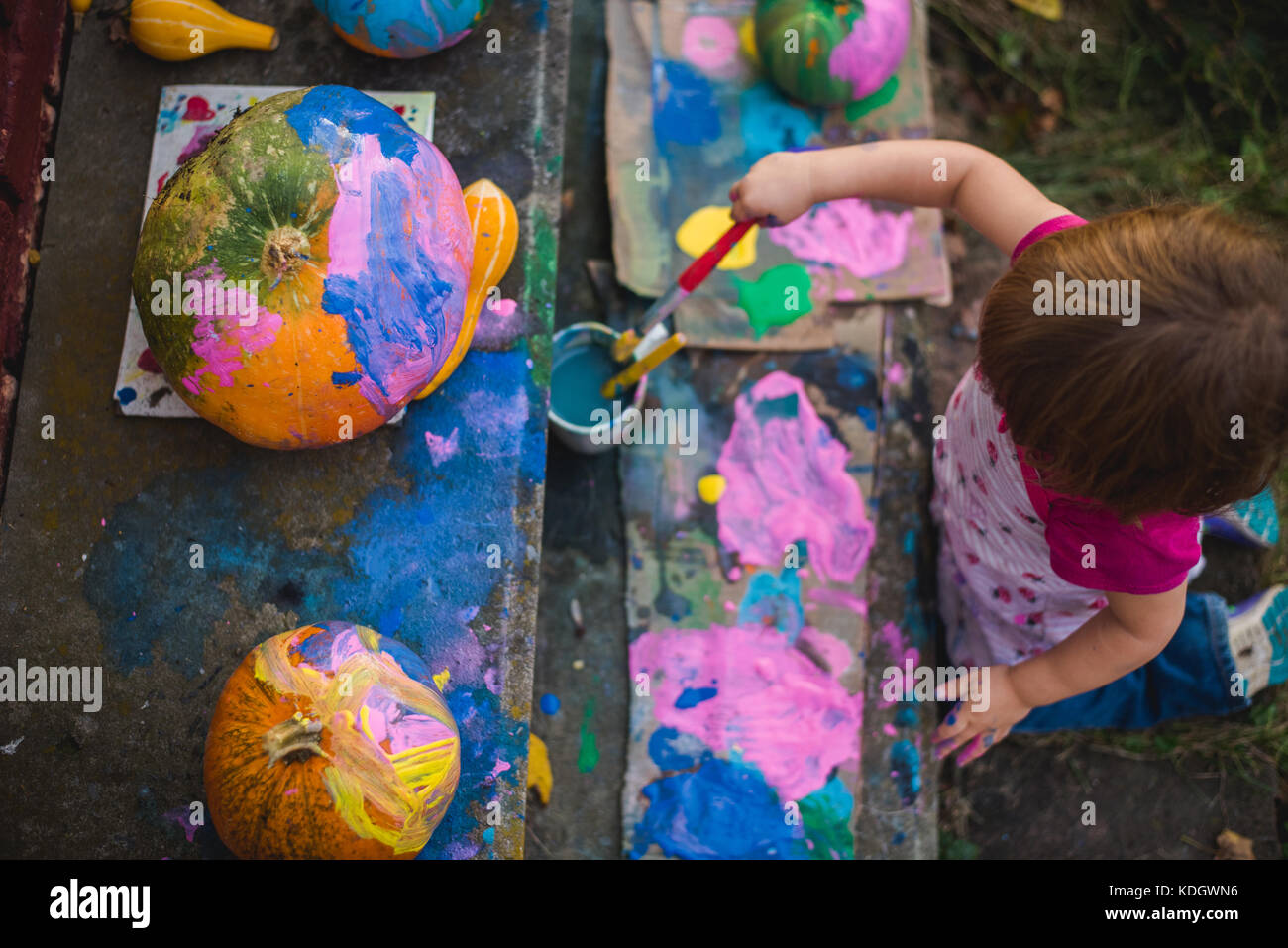 Una bambina vernici zucche durante le attività di autunno. Foto Stock