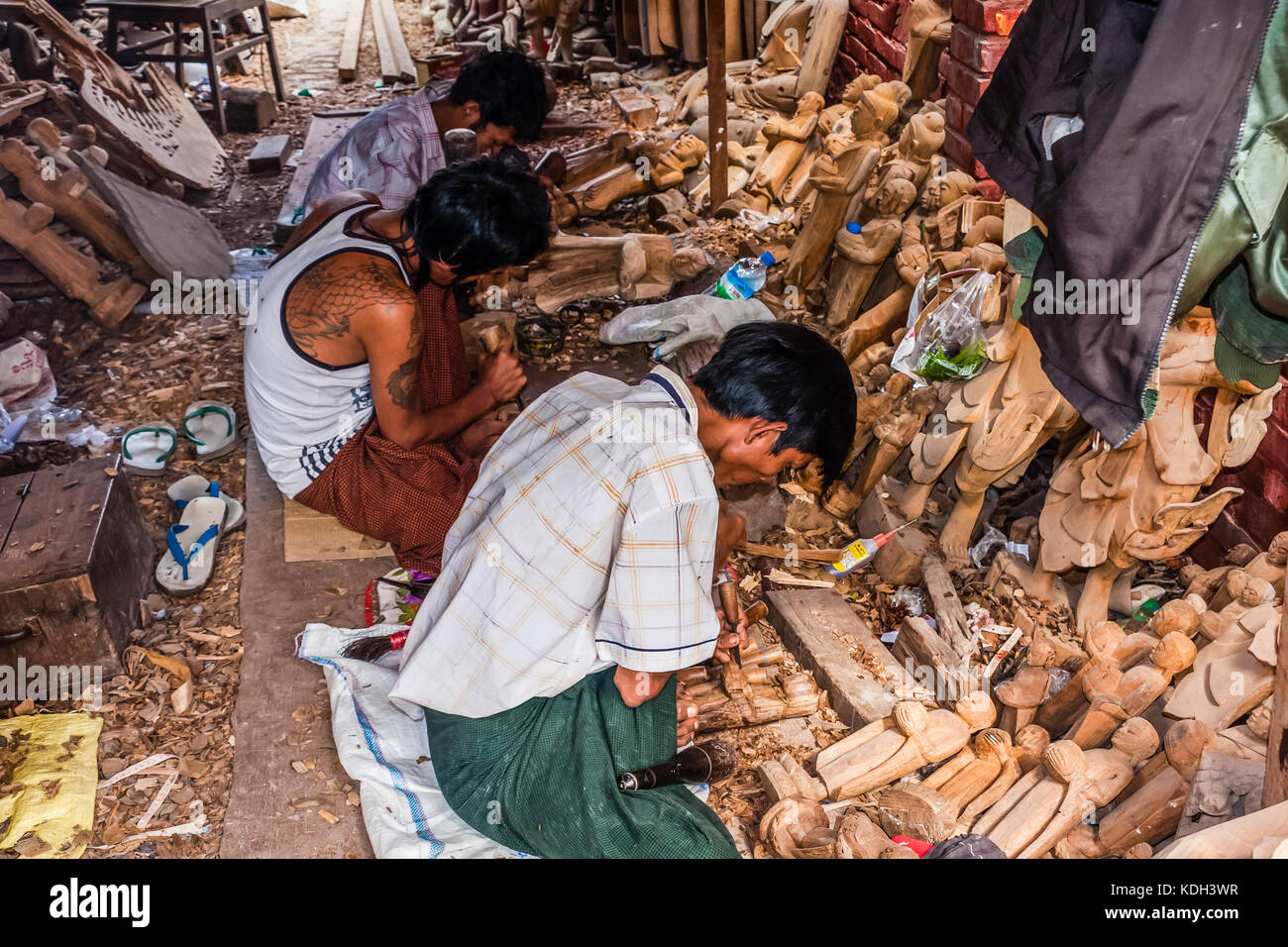 Intagliatori di legno al lavoro che si crafting le figurine di Buddha, Mandalay, Myanmar Foto Stock