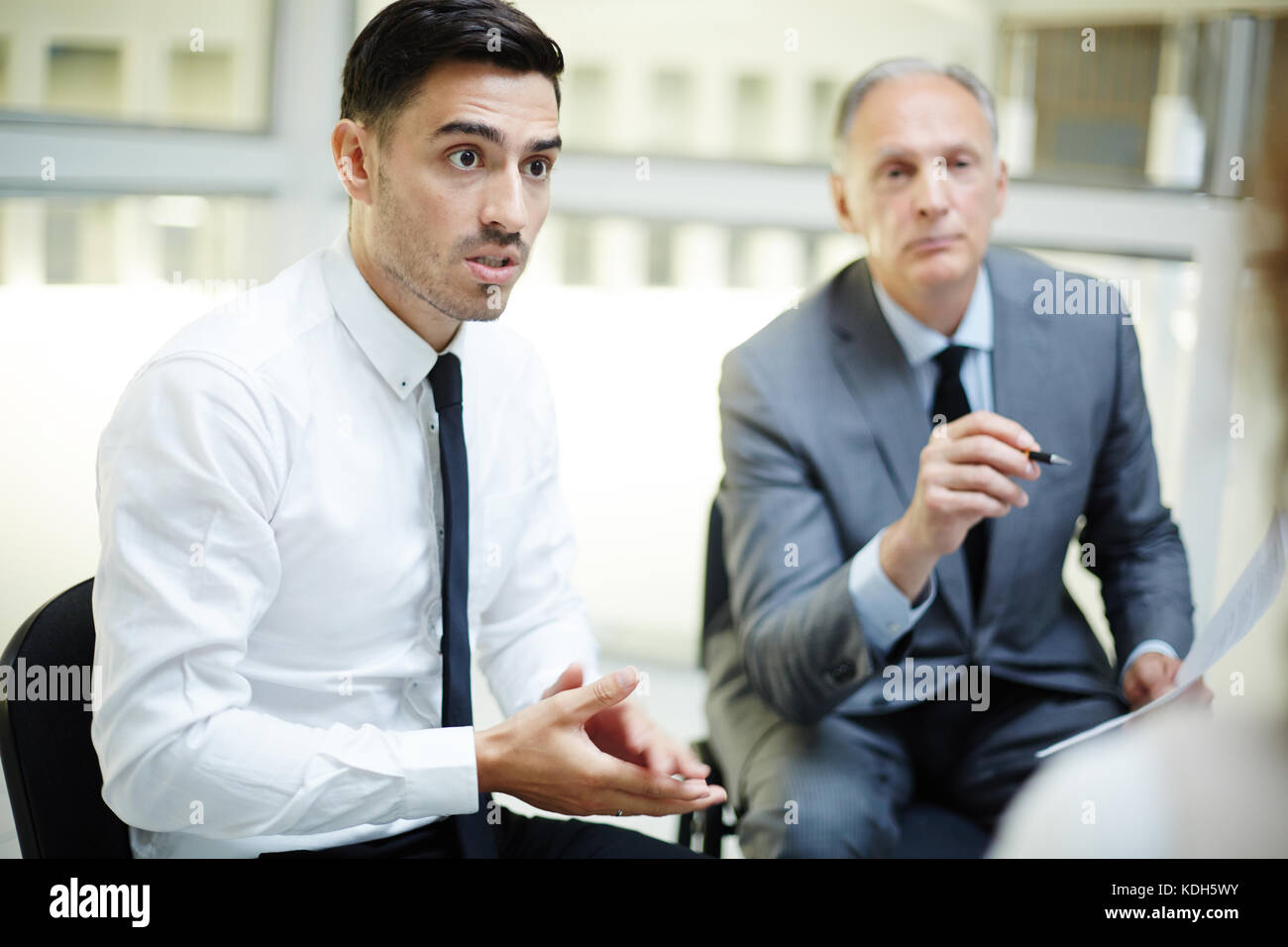 Giovane e maturo uomini d'affari di parlare fuori quello che pensano circa la presentazione Foto Stock