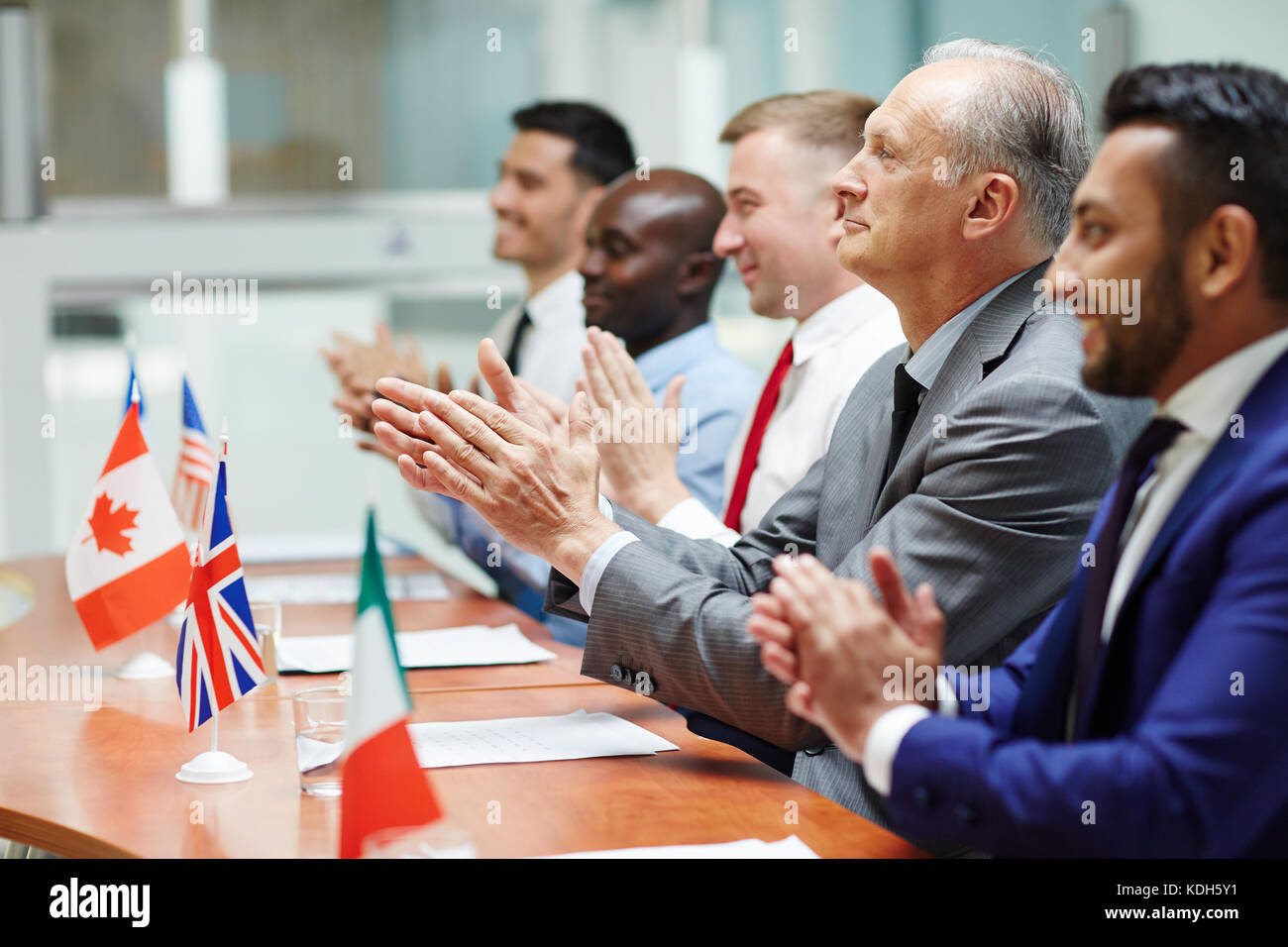 Fila di delegati battendo le mani dopo aver parlato di successo di collega Foto Stock