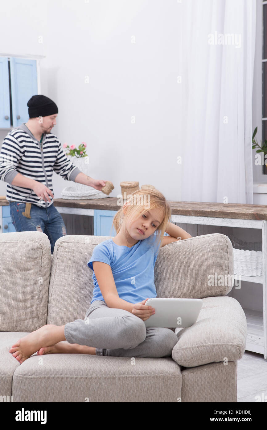 Malati piccolo bambino seduto sul divano guardando cartoni animati su tablet. Foto Stock