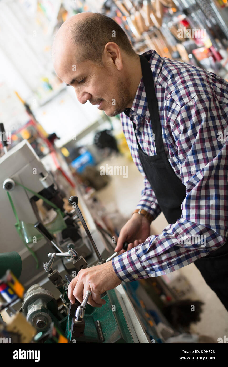 Felice european senior professional con diversi tipi di chiavi a Fabro Foto Stock