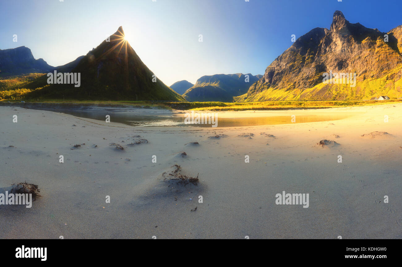 In Norvegia la spiaggia della sabbia al mattino. sole splende dietro la roccia alla spiaggia. Foto Stock