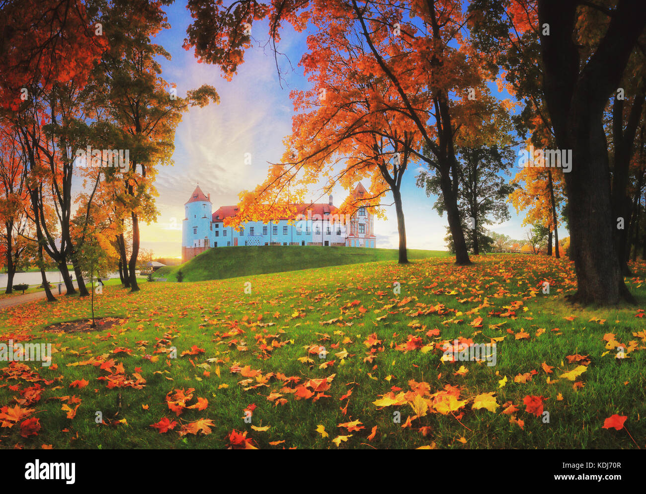 Serata autunnale nel Parco. complesso del Castello di Mir in autunno sera. colorato fogliame di autunno su erba in omaggio. Foto Stock