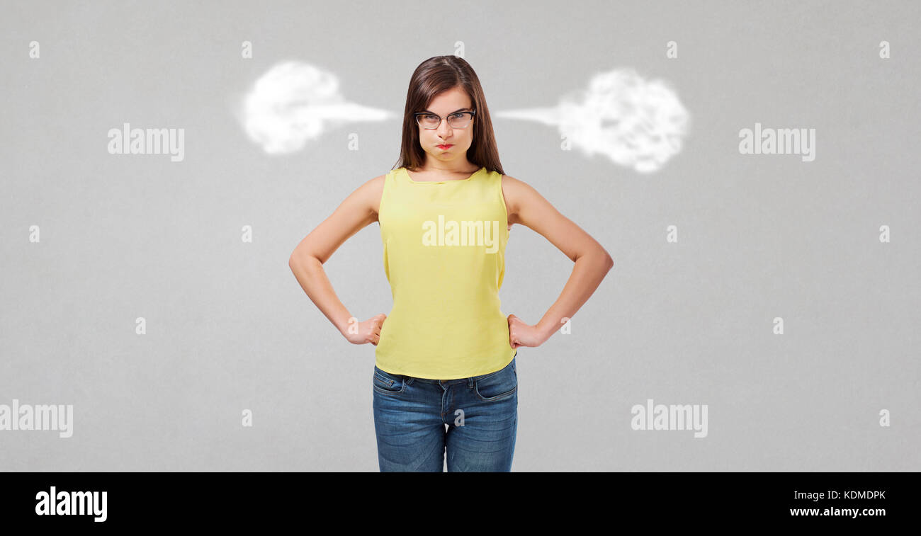 Insoddisfatto wicked girl su sfondo grigio. Foto Stock
