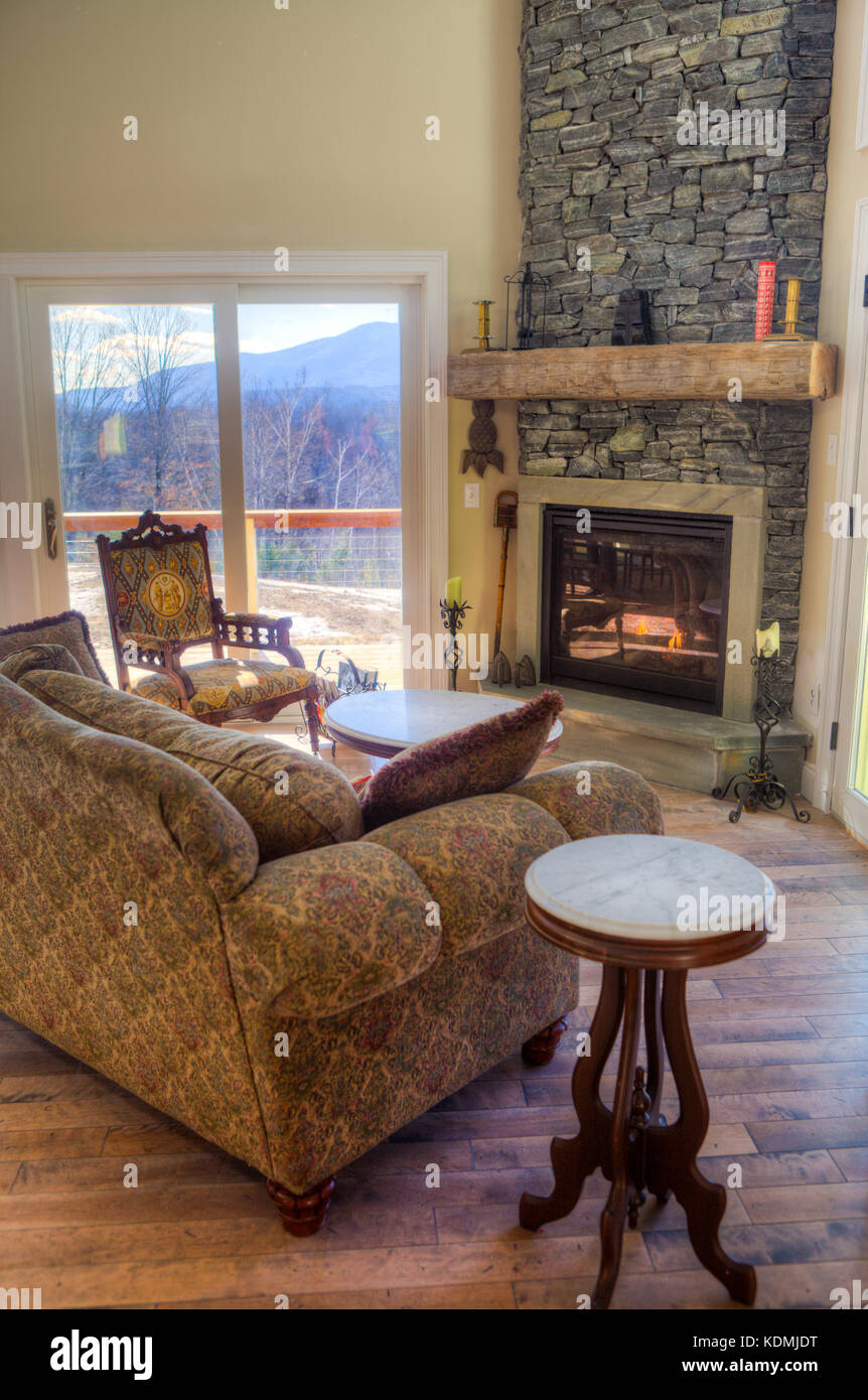 Moderno, elegante soggiorno con cucina adiacente sala da pranzo e caminetto in pietra nel Vermont, USA. Foto Stock