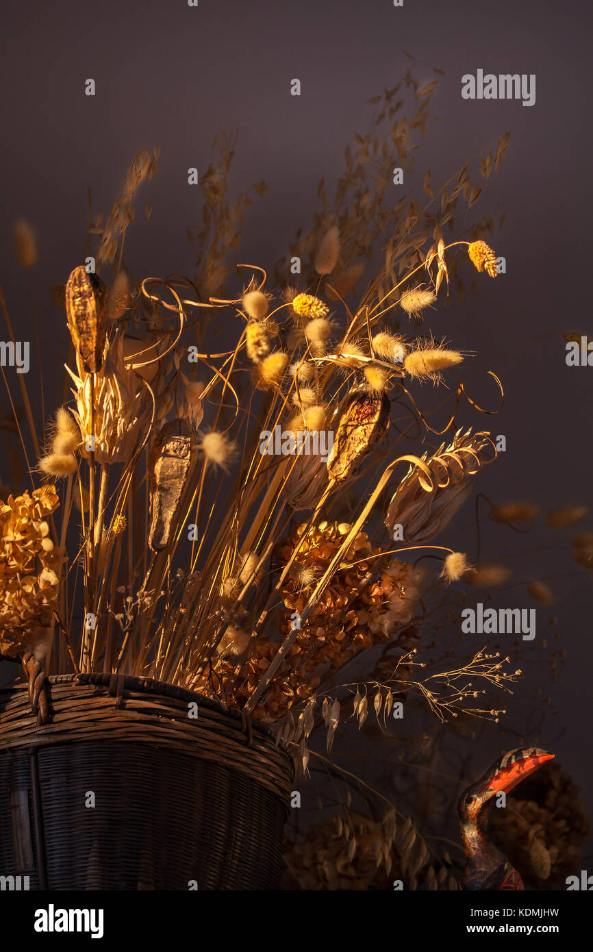 Un cesto tessuto di erbe secche, cardi e altre piante selvatiche decora una casa interno. Foto Stock