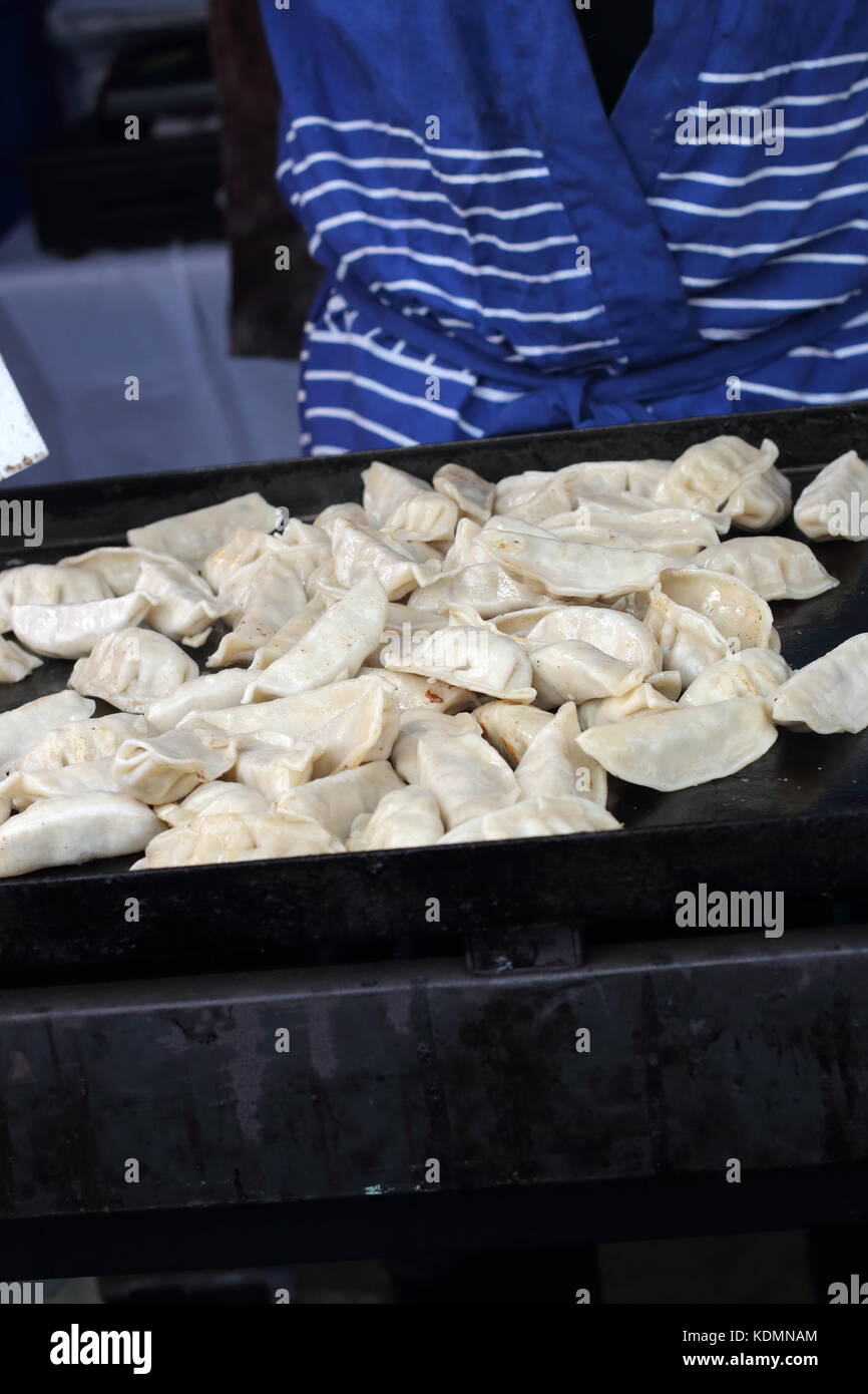 Gnocchi di asiatici in cottura su una piastra calda Foto Stock