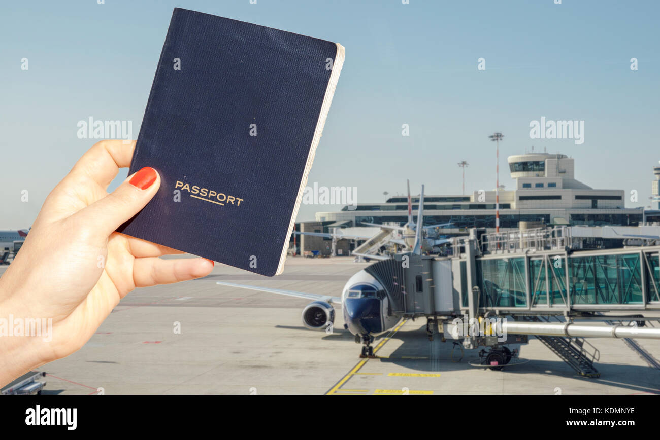 Composito Digitale della mano che tiene un generico passaporto con occupato terminal dell aeroporto di sfondo sfocato Foto Stock