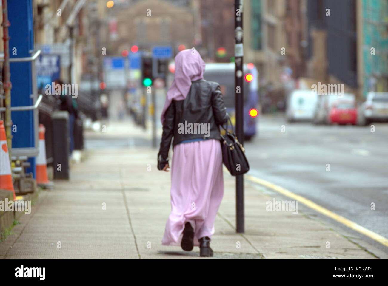 Donna musulmana in sciarpa alla testa che cammina per la strada cittadina di Glasgow, Scozia, sciarpe hijab del Regno Unito Foto Stock