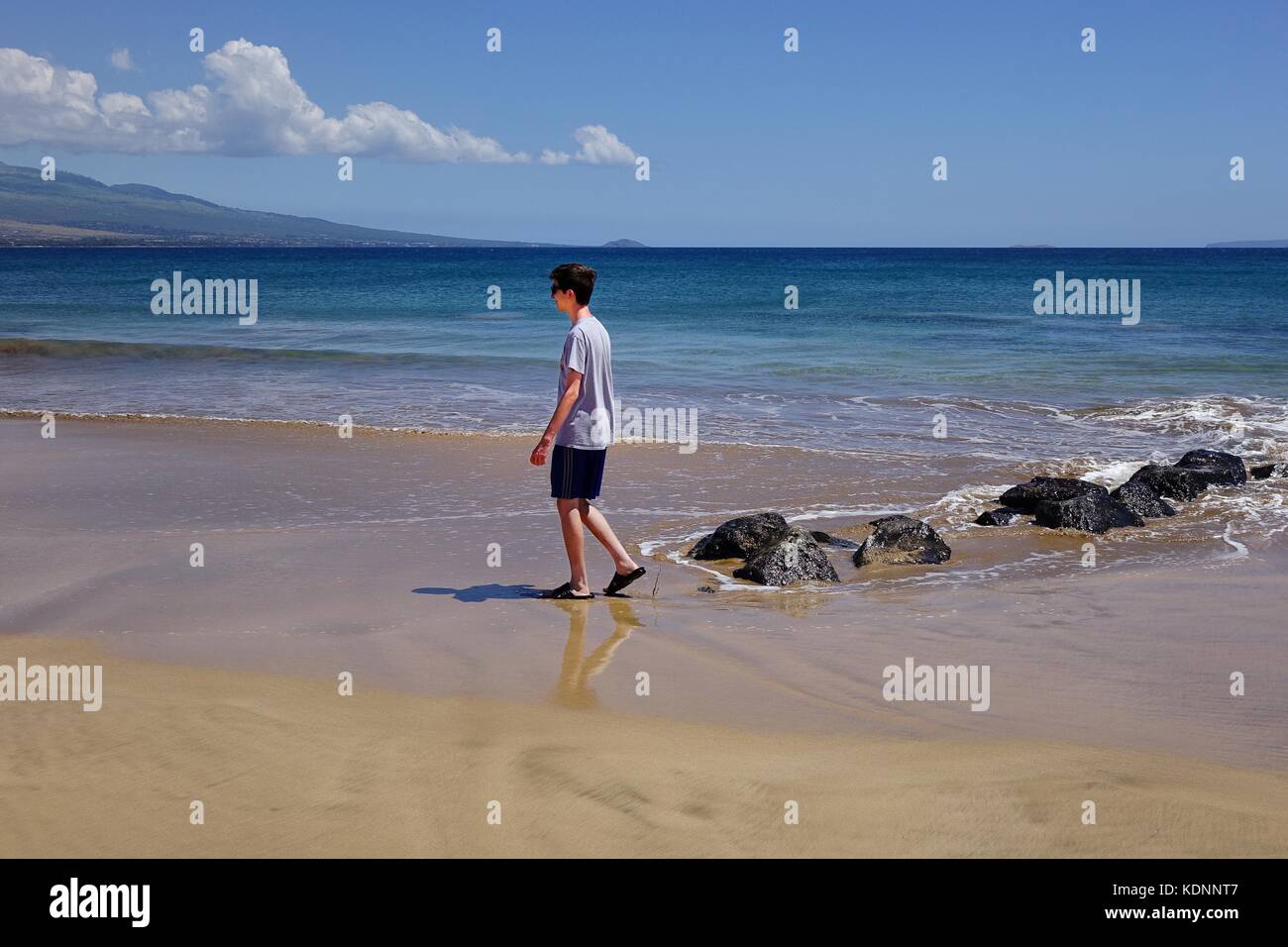 Adolescente passeggiate sulla spiaggia di Maalaea Bay, Maui, Hawaii Foto Stock