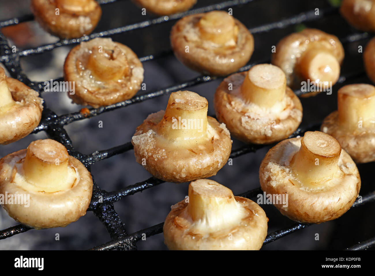 Bianco comune champignon funghi cotti su char grill, vicino ad alto angolo di visione Foto Stock
