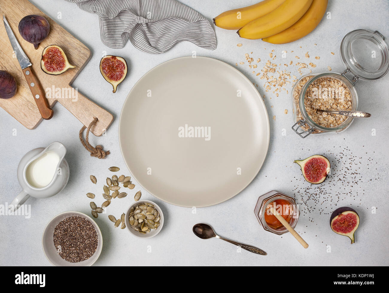 Ingredienti per la prima colazione: fiocchi d'avena, latte, fichi, banane, chia semi, miele, semi di zucca. vista da sopra Foto Stock