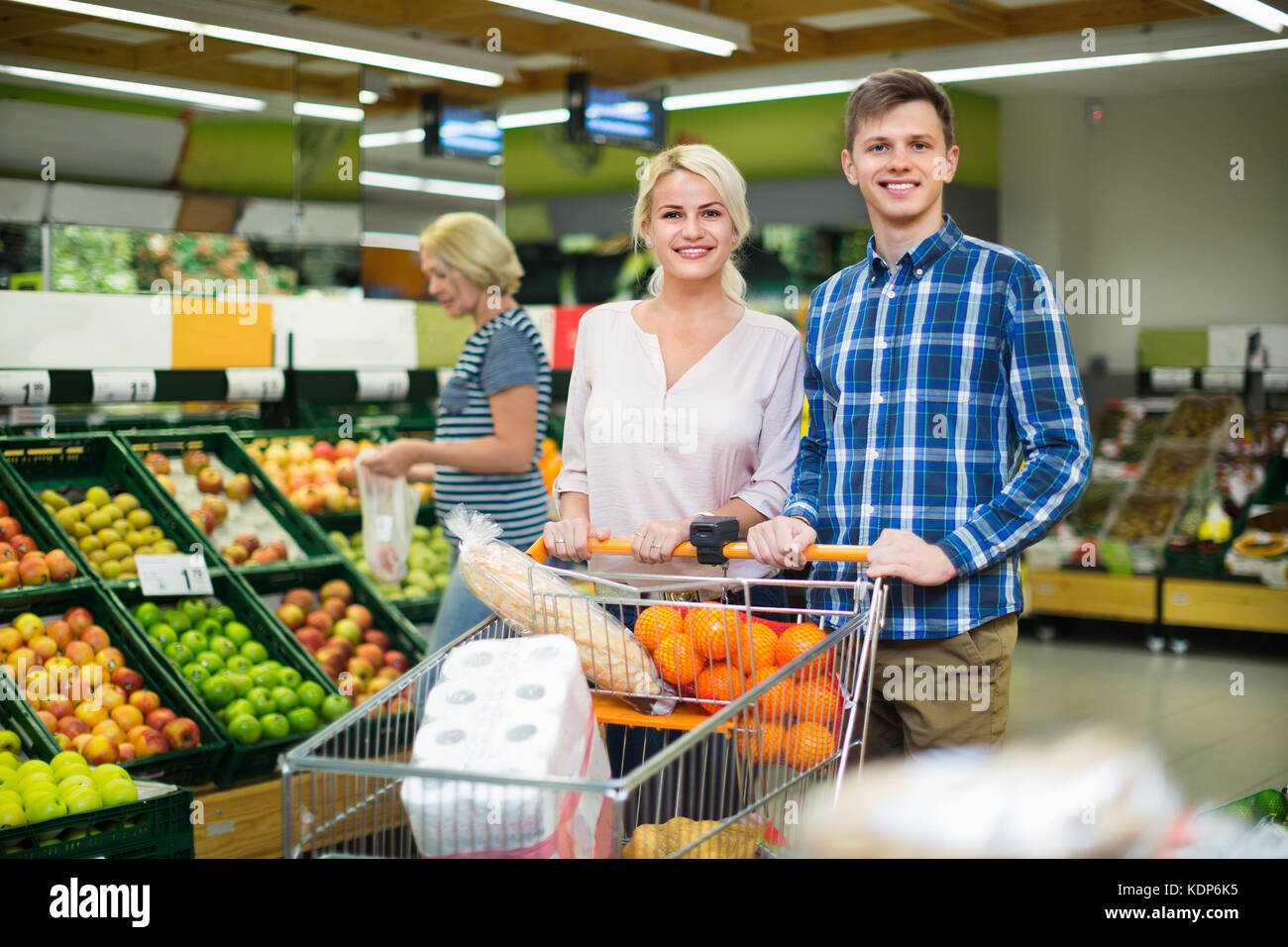 Positivi i clienti sorridenti scegliendo frusits fresco nel supermercato locale Foto Stock