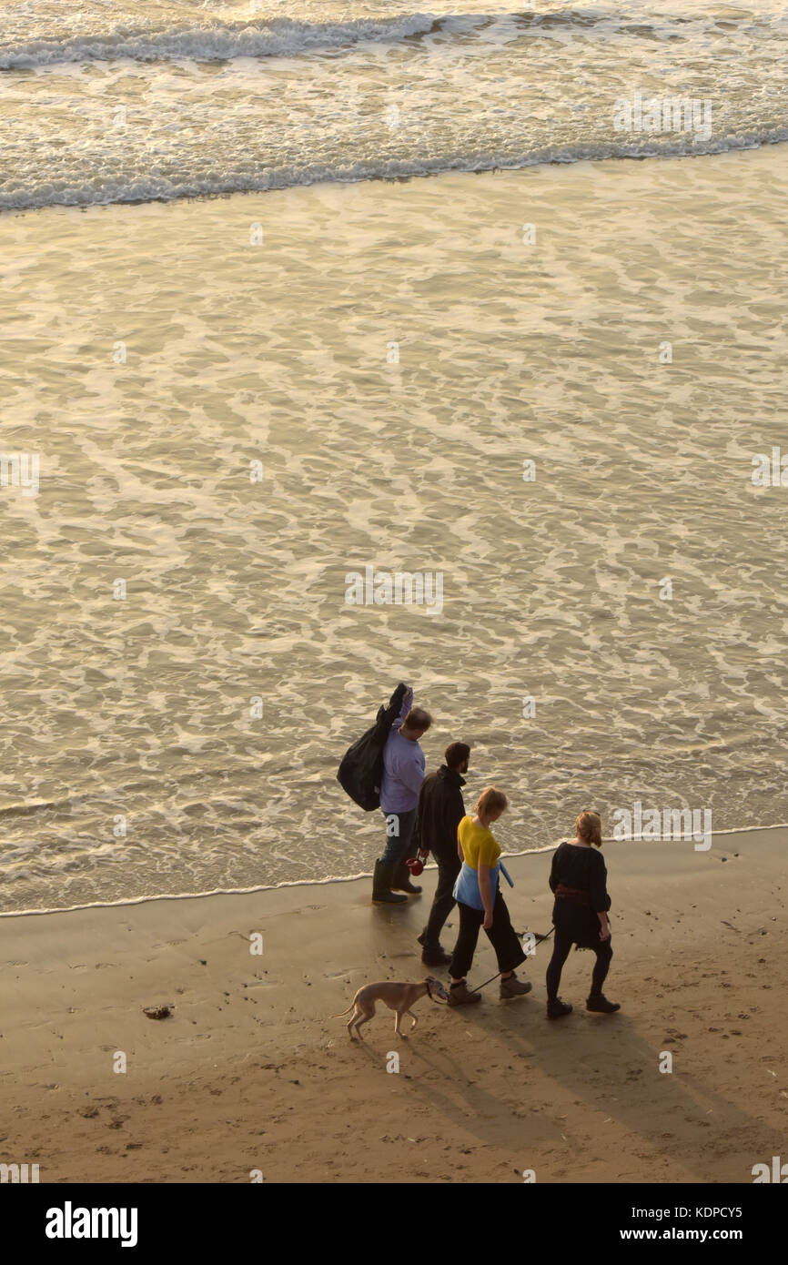 Una famiglia passeggiate con il cane sulla spiaggia al tramonto sull'isola di Wight. Foto Stock