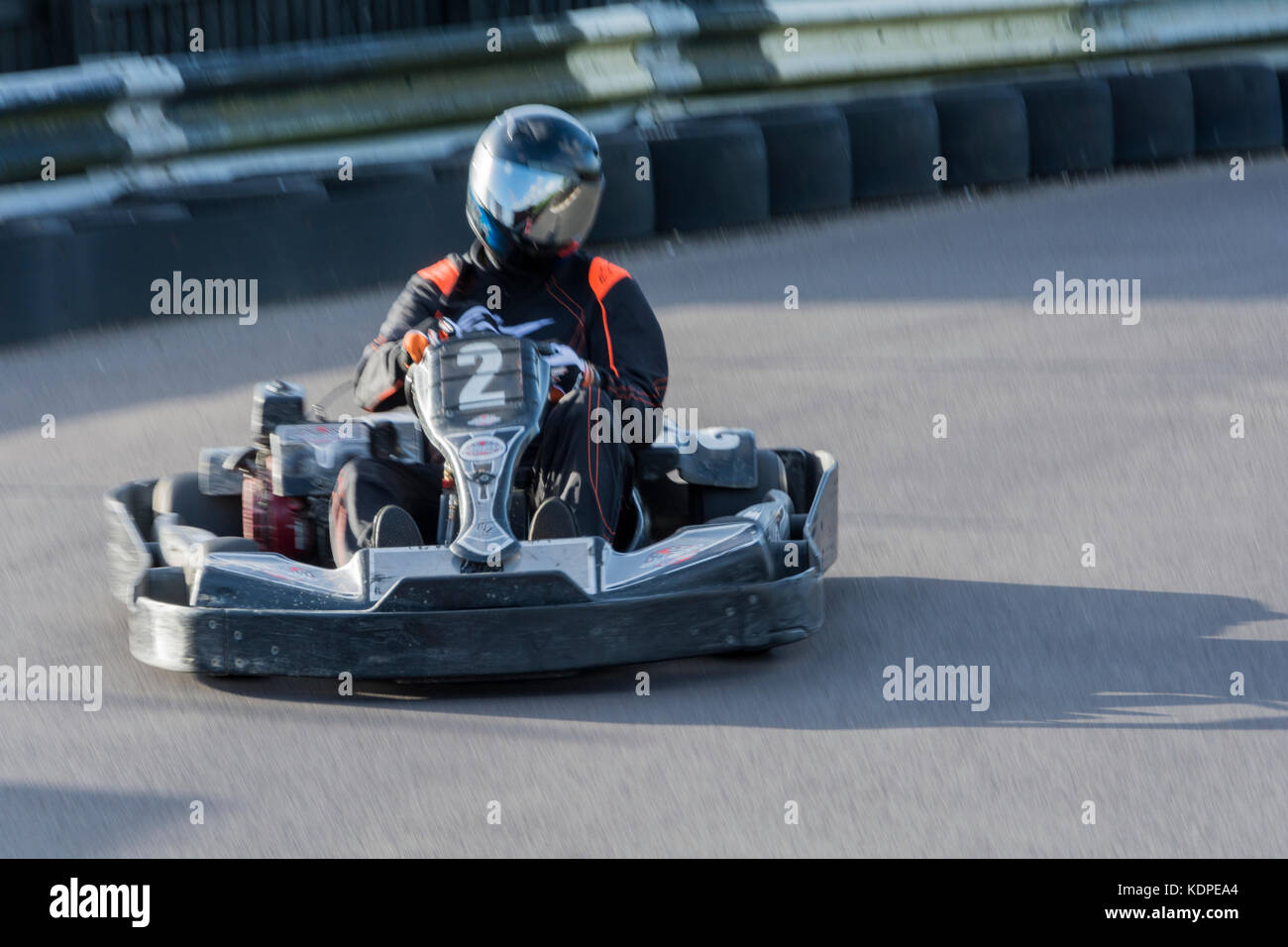 Uomo alla guida di una vettura di Go-Kart a velocità su una pista da corsa Foto Stock