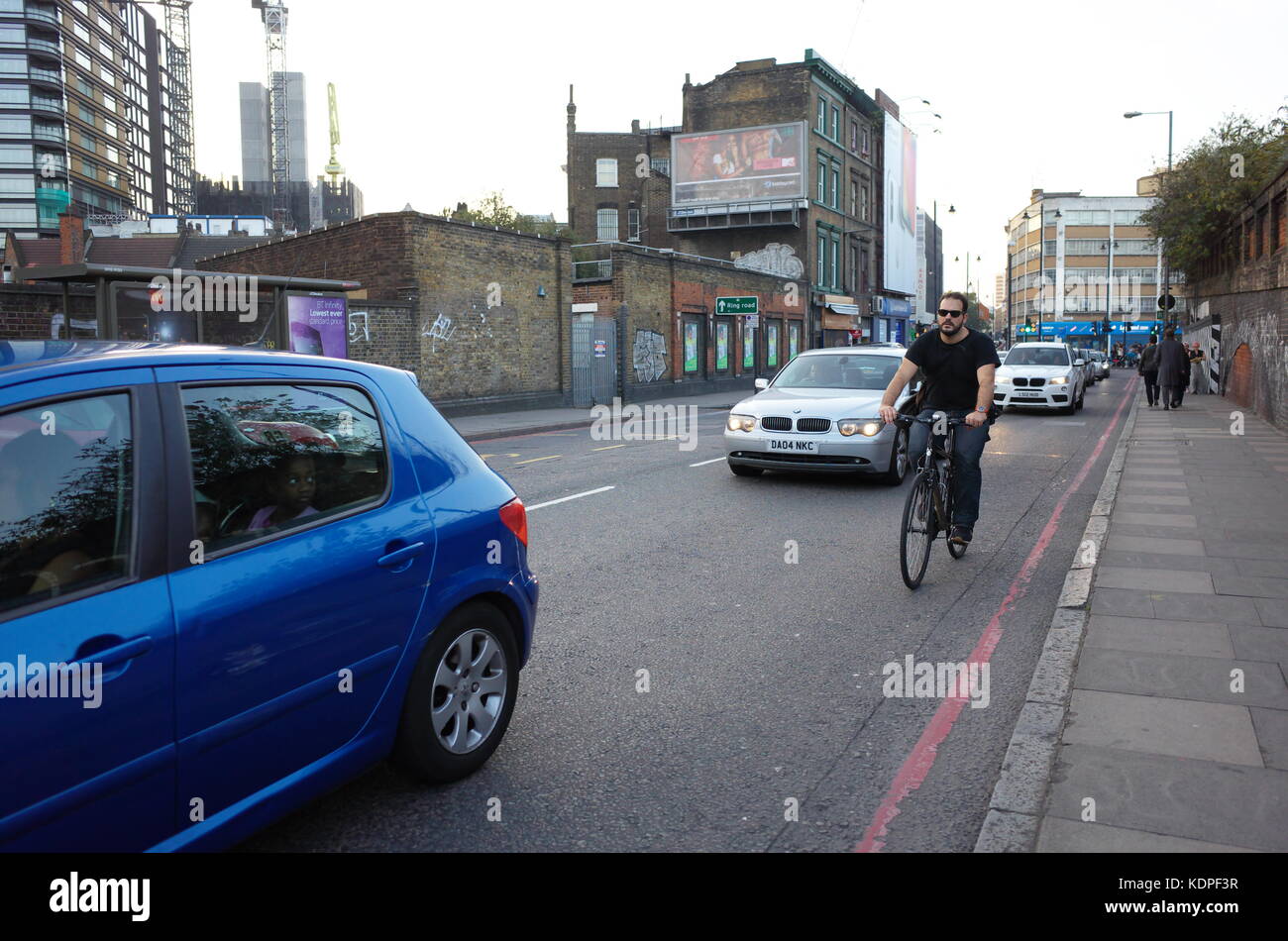 Escursioni in bicicletta lungo il lato del traffico di veicoli a Londra in Inghilterra Foto Stock