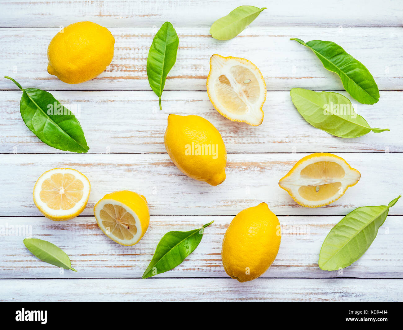 Limoni freschi Limoni e foglie sul legno rustico sfondo. limoni freschi e  la fetta di limone su un tavolo di legno con piatto laici. agrumi freschi  sul malandato Foto stock - Alamy
