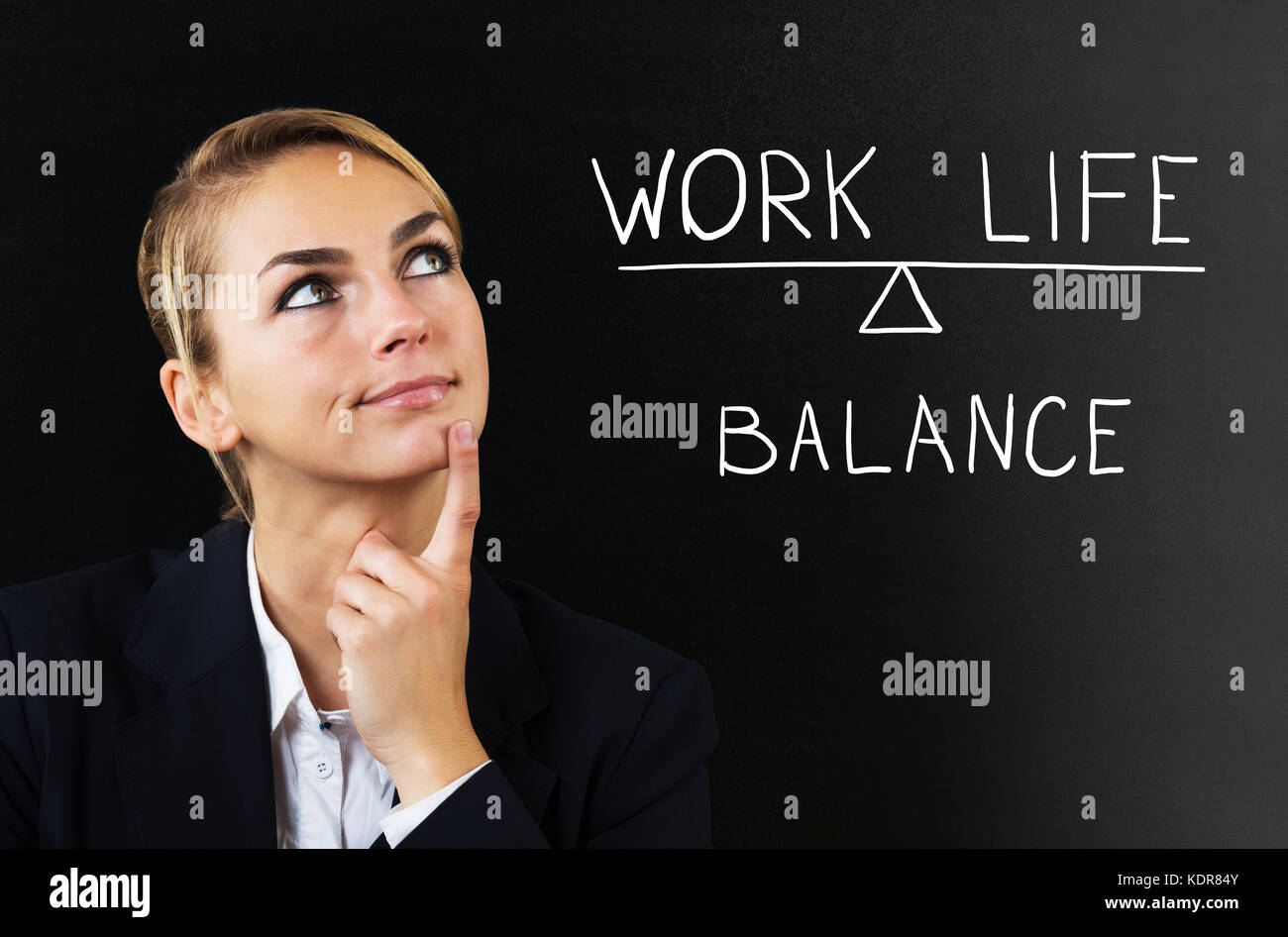 Giovane donna di Businesswoman che pensa al lavoro di bilanciamento vita su sfondo nero Foto Stock