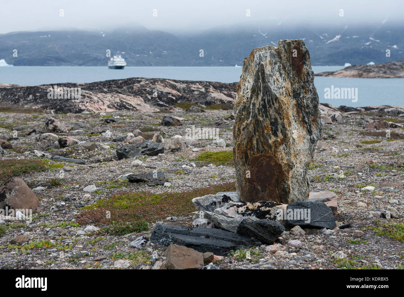 Groenlandia, Scoresbysund aka Scoresby Sund, Hekla Havn, rovine di Danmark O. di 200 anni anelli di tenda inuit vecchio. Spedizione in lontananza. Foto Stock
