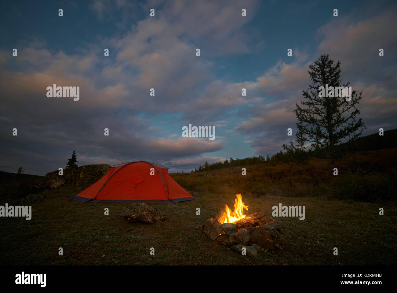 Una tenda e falò sotto un cielo di sera Foto Stock