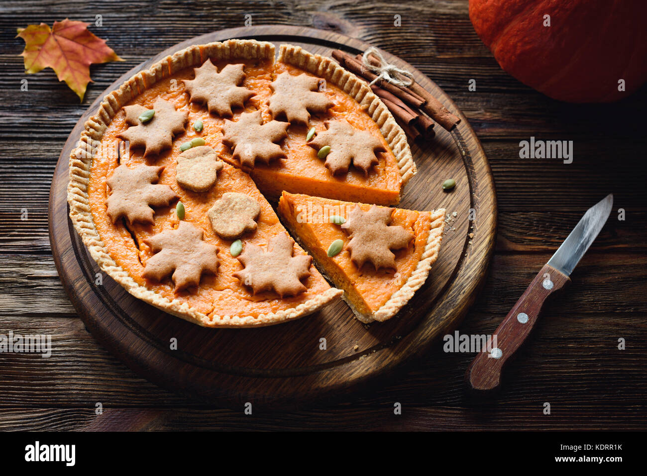 In casa torta di zucca decorata con pan di zenzero cannella cookie sul tavolo di legno. tutta la torta di zucca Foto Stock