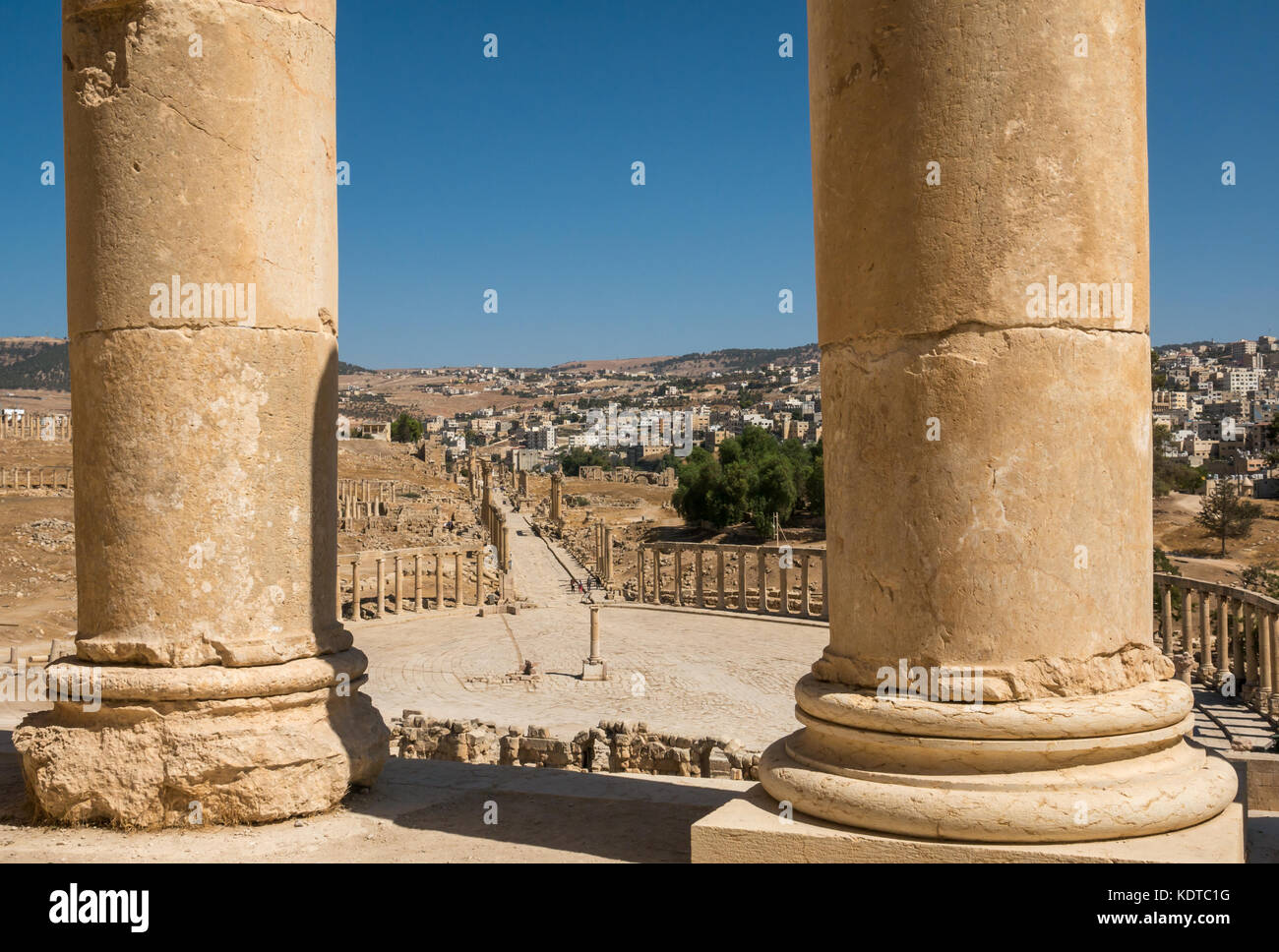 Cerca tra le colonne a ovale Plaza e il Cardo, città romana di Jerash, antica Gerasa, sito archeologico in Giordania, Medio Oriente Foto Stock