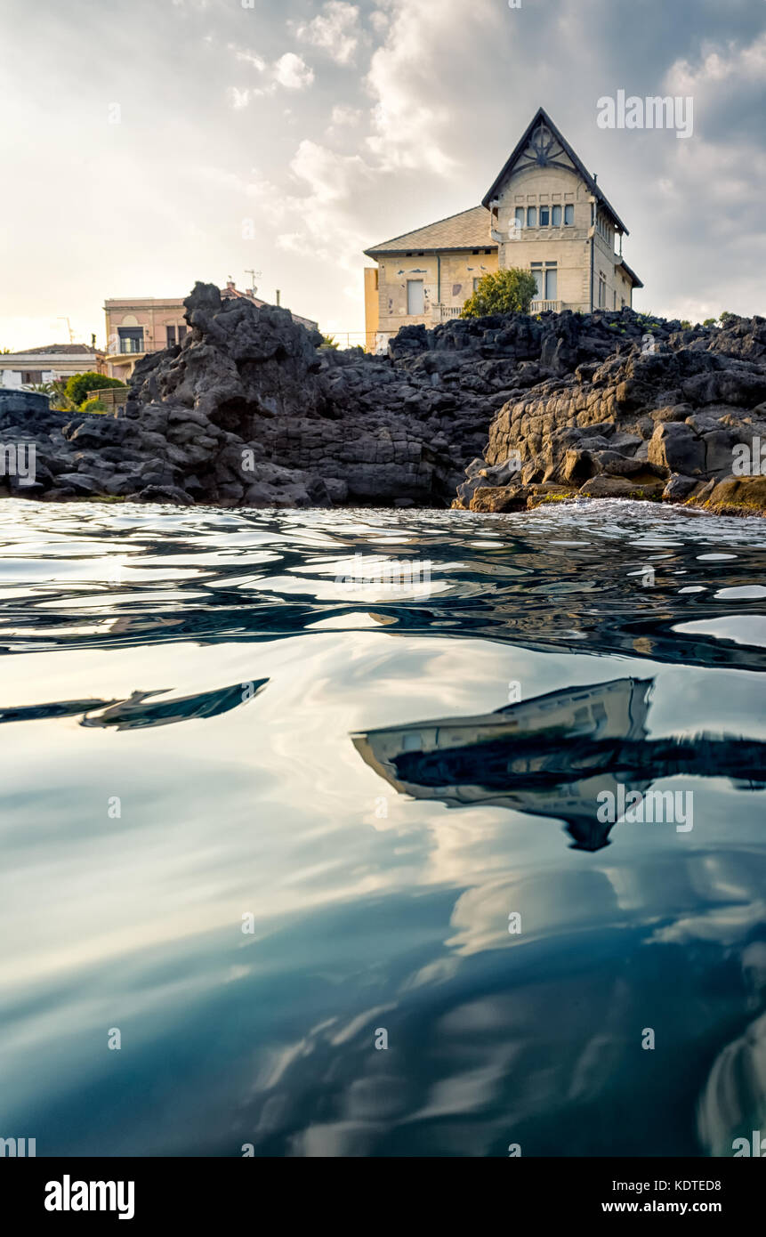 Bella estate di lusso case con vista sul mare si riflette al tramonto, Catania, Sicilia, Italia Foto Stock