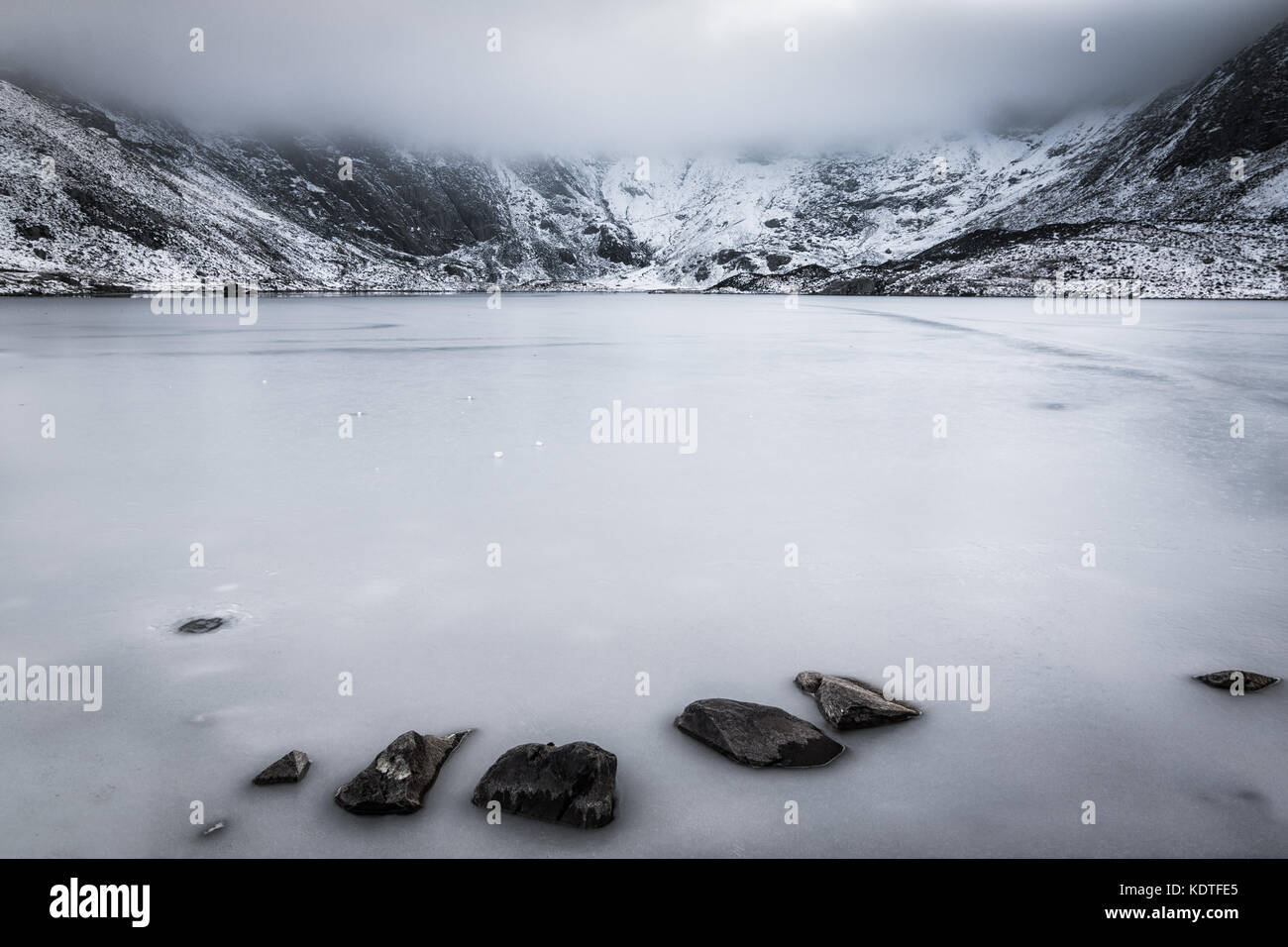 Llyn Idwal con lago ghiacciato e la nebbia bassa formata nel periodo invernale, Ogwen, Wales, Regno Unito Foto Stock