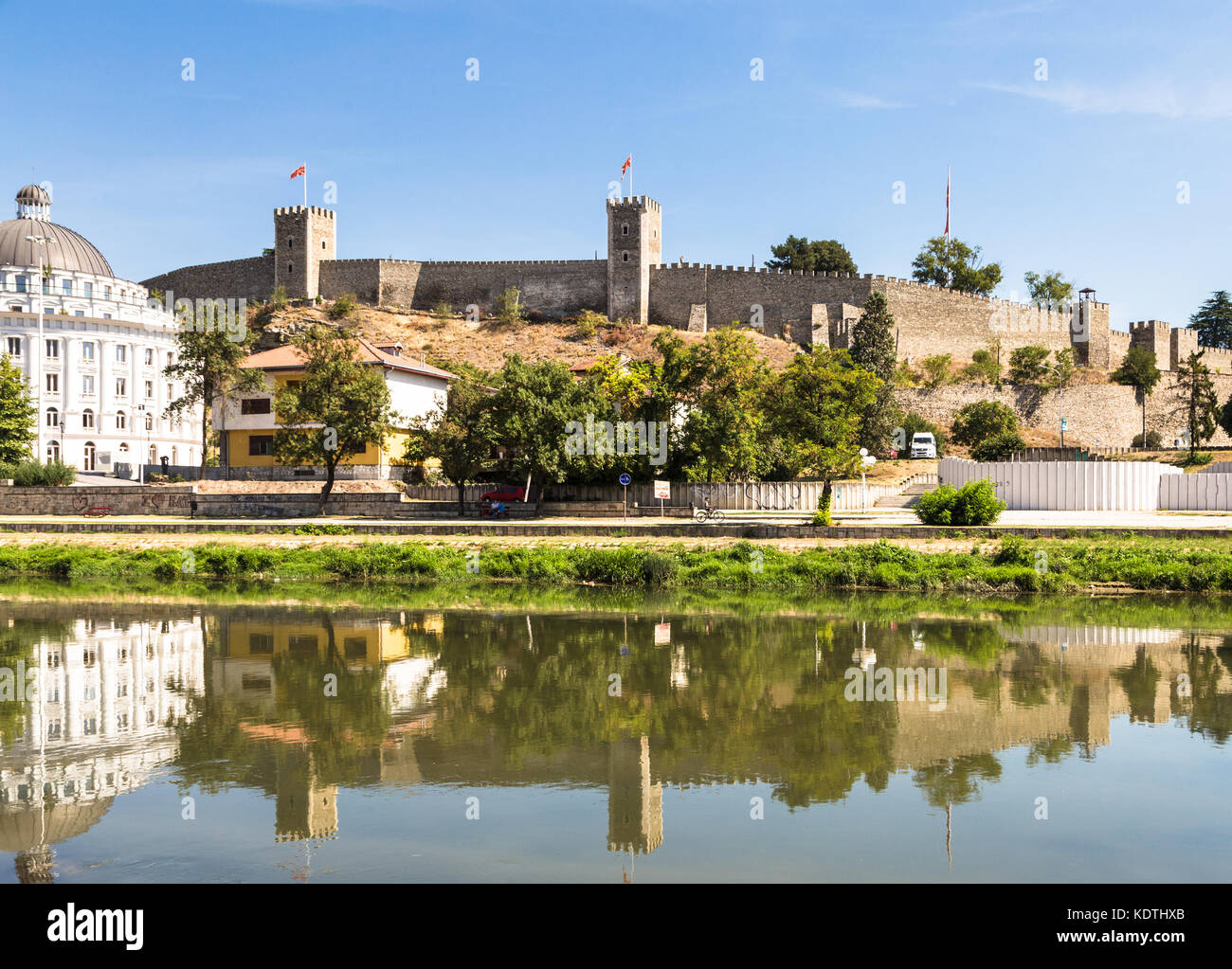 Skopje cityscape con la famosa cittadella di Skopje e la fortezza Kale riflettendo nell'acqua del fiume Vardar su una soleggiata giornata estiva in Macedonia c Foto Stock