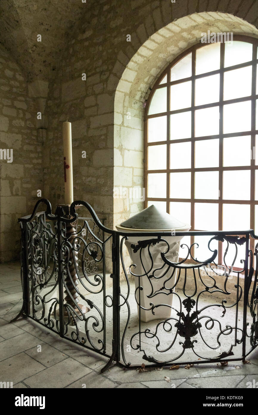 Souillac, Francia. Font e il cero pasquale. Chiesa di Saint Marie. Foto Stock