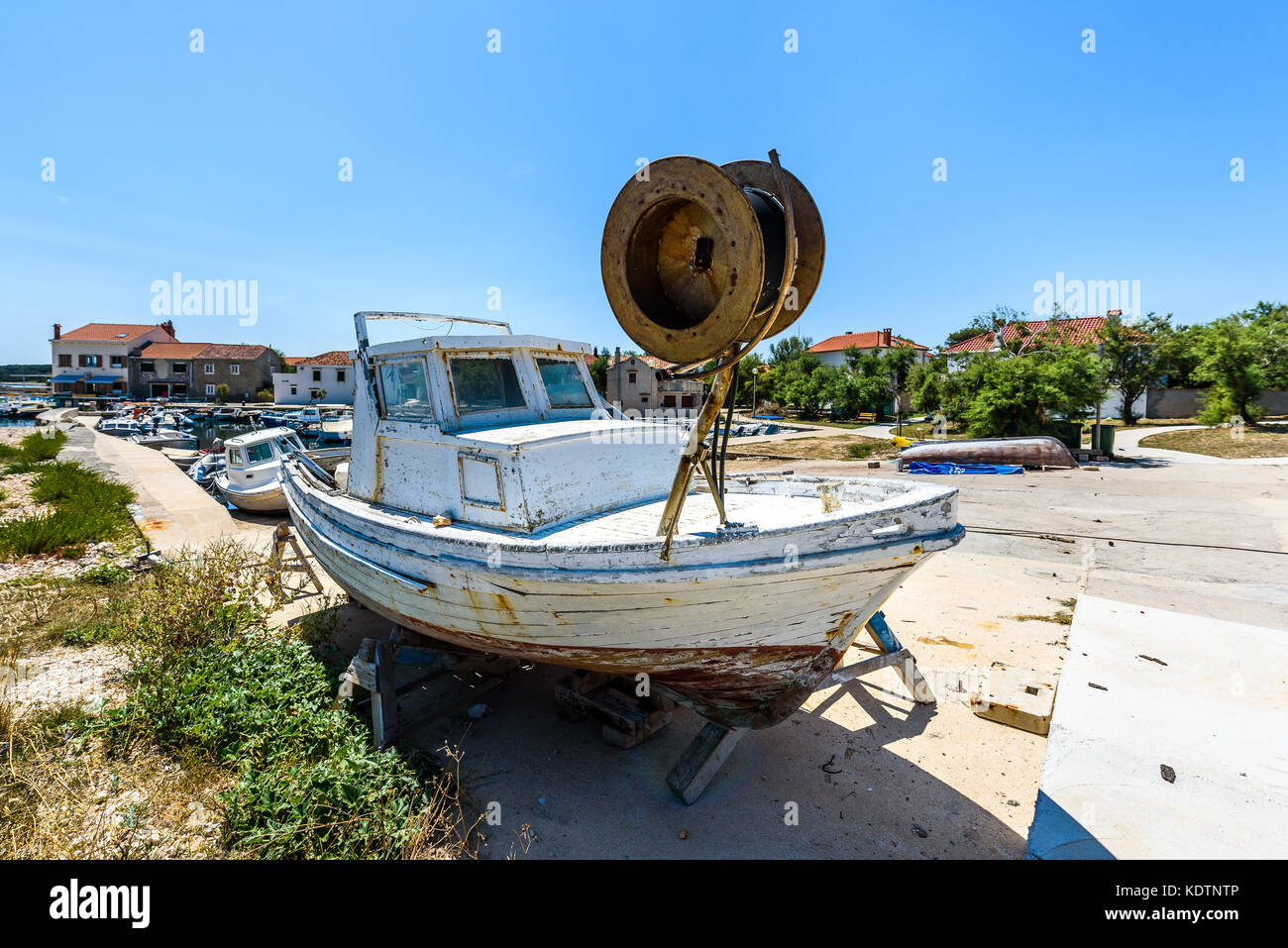 Riparazione e restauro di vecchi in legno nave da pesca o barca. vecchio weathered barca da pesca montata su martinetti in legno per il bacino di carenaggio riparazione e ristrutturazione con Foto Stock