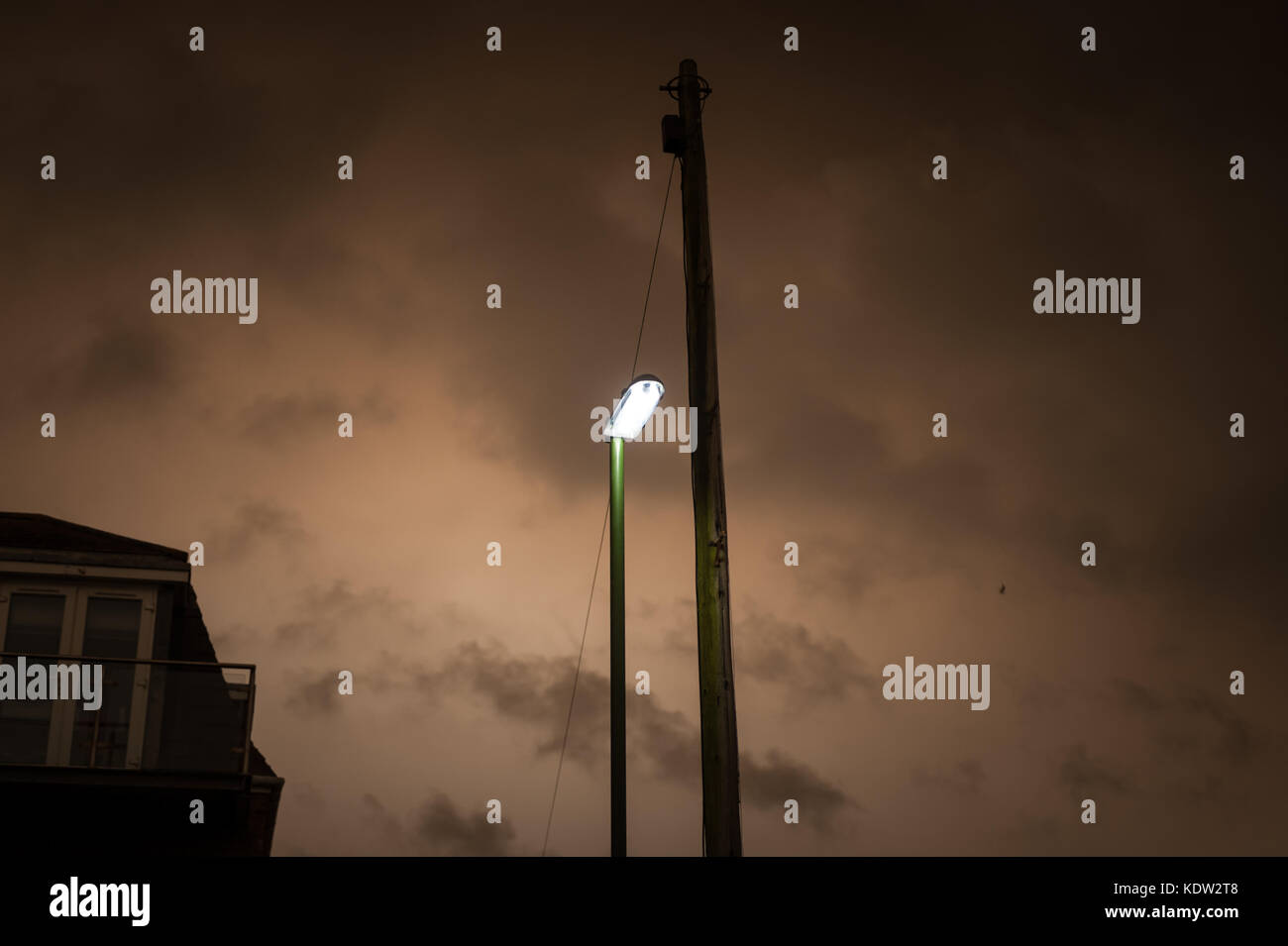 Street si accendono come il giorno si trasforma nella notte in Littlehampton West Sussex, in Inghilterra. Il cielo si è oscurato e uno strano bagliore arancione è apparso nel bel mezzo della giornata. Rapporti dire il fenomeno è stato causato dalla ex uragano, Storm Ofelia, tirando in aria e polvere dall'Europa meridionale e in Africa. Foto Stock