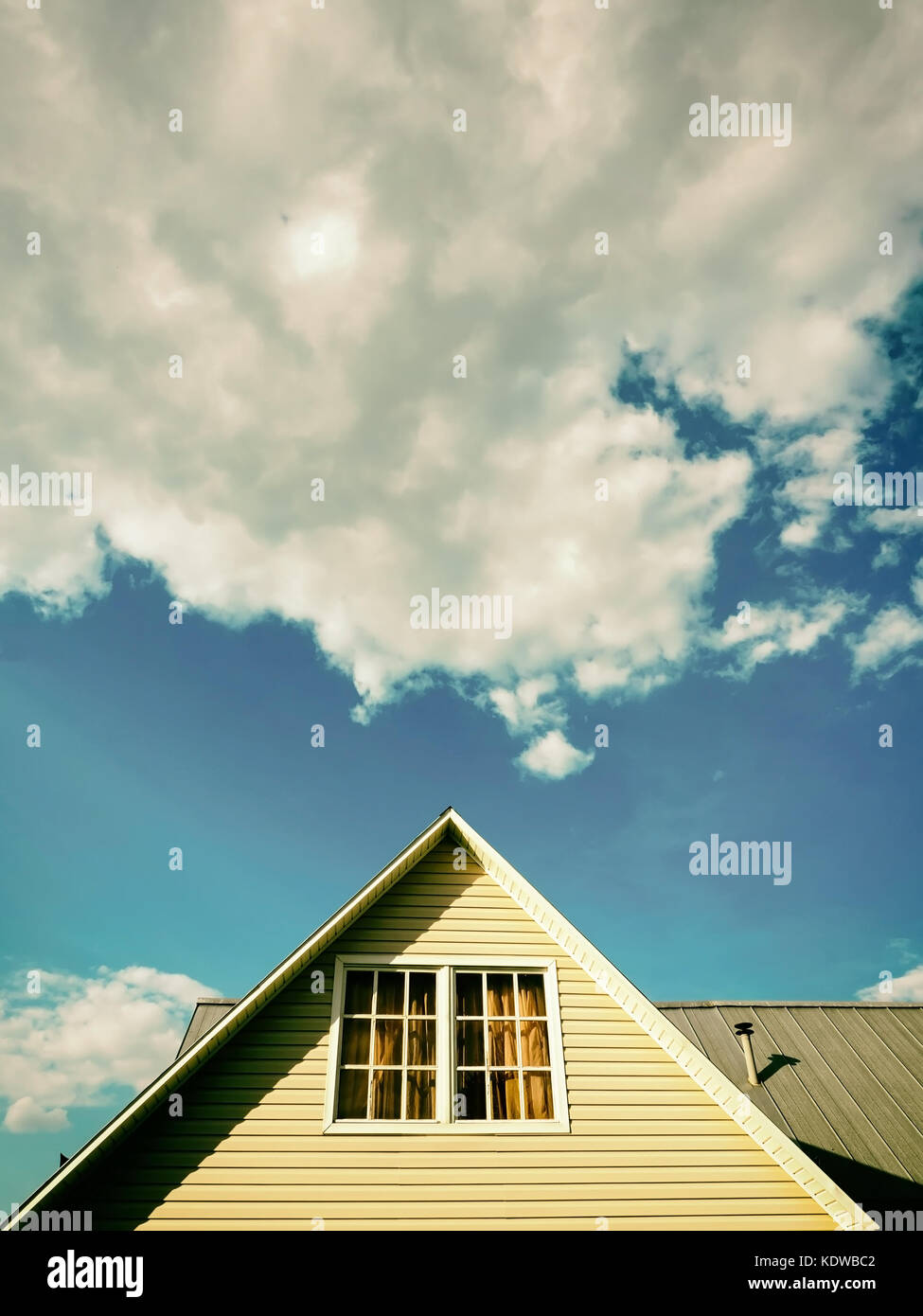 Una casa di campagna tetto contro il cielo blu e cloud, look vintage Foto Stock