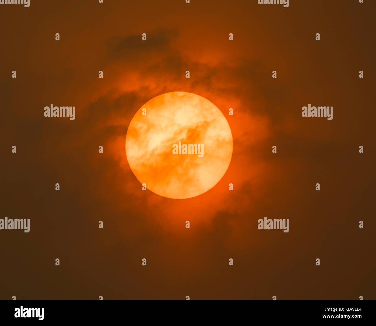 Sun Red nel Devon. Strano skies causata dal basso livello sun colpendo gli strati del cloud e possibilmente la polvere in atomspere. Foto Stock