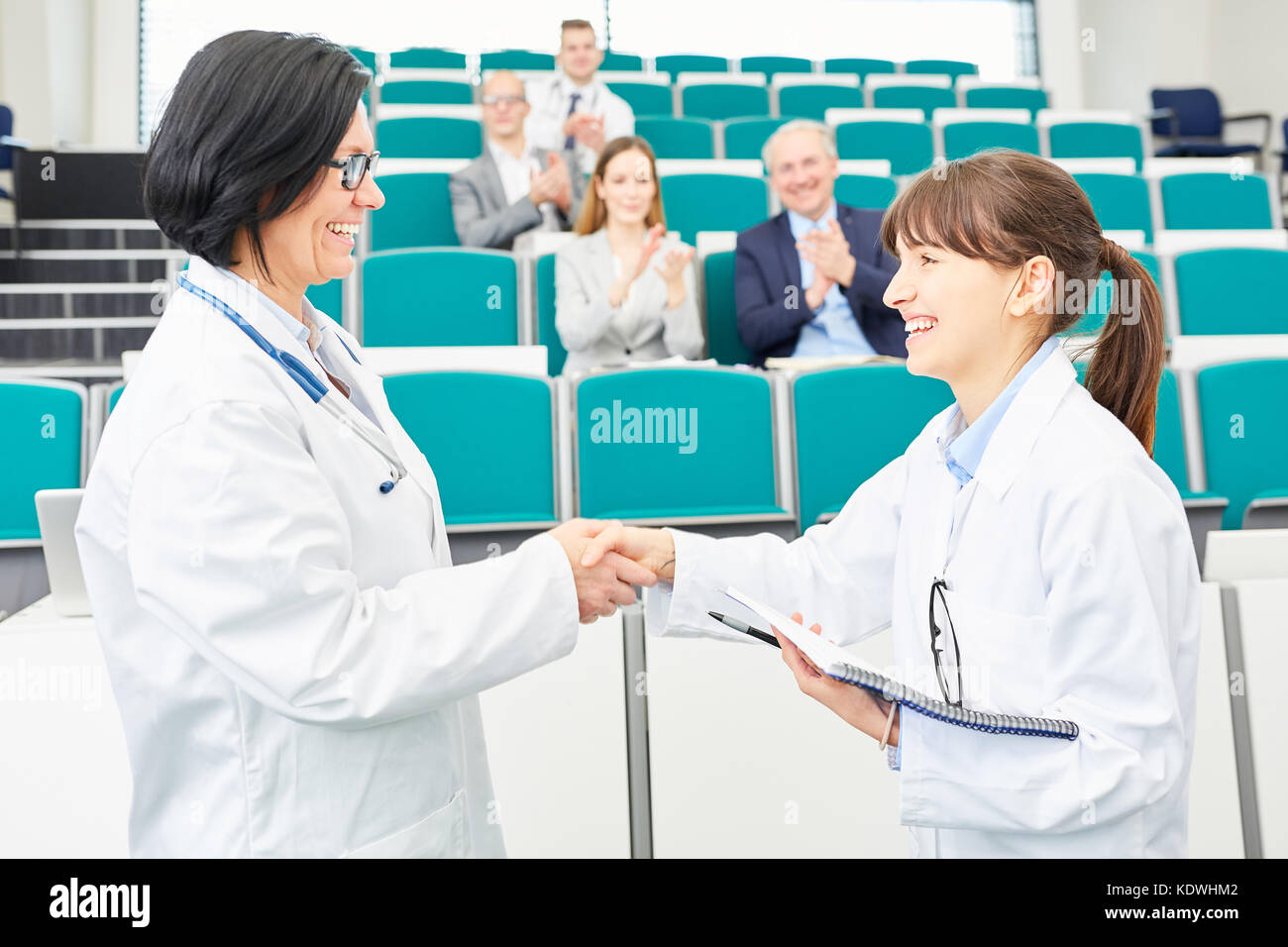 I medici congratulazioni la stretta di mano tra studente e insegnante Foto Stock
