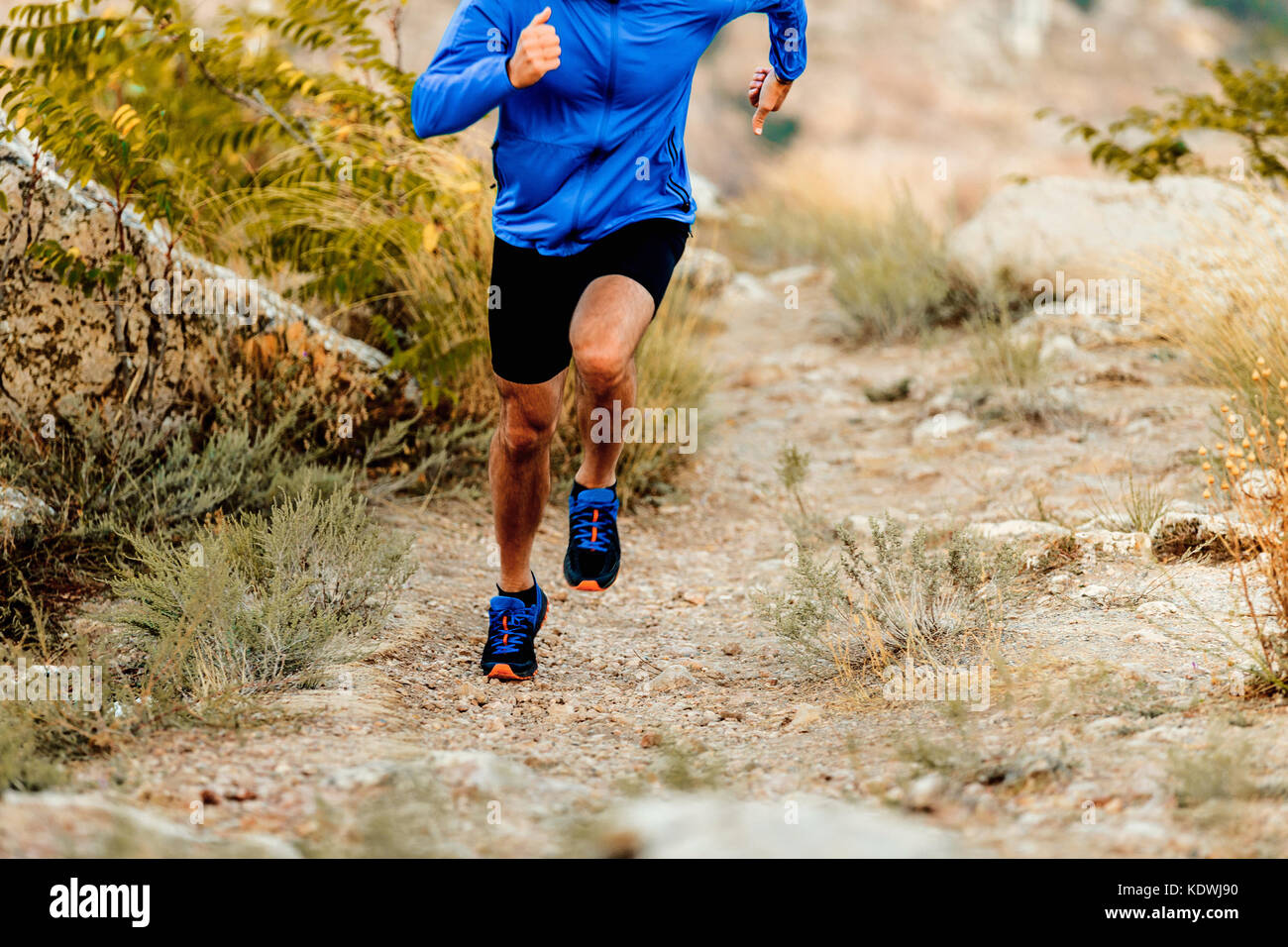 La velocità in esecuzione sul sentiero di montagna atleta maschio runner Foto Stock