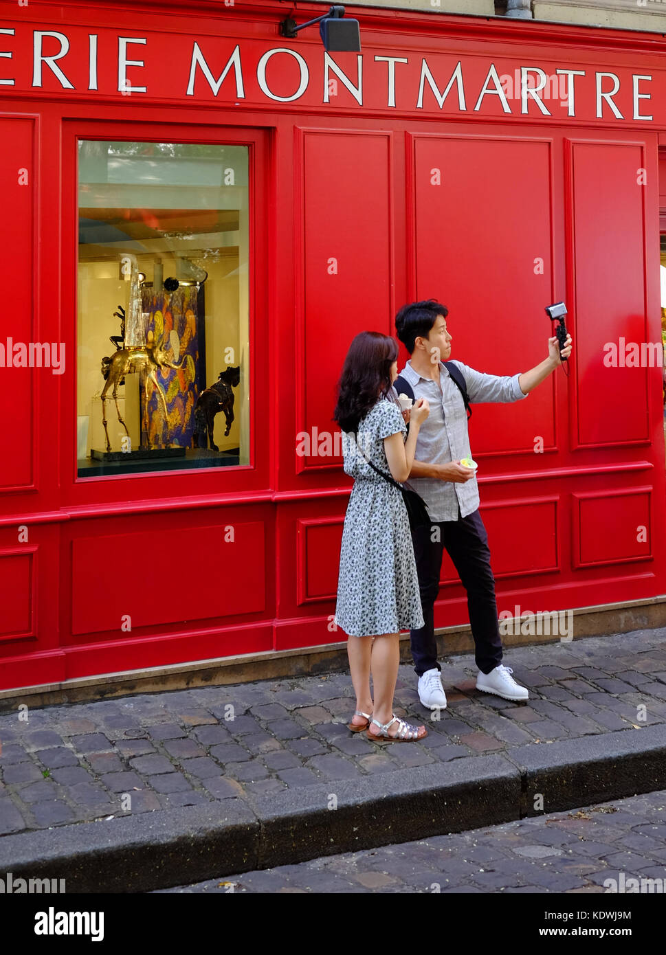 Un giovane turista giovane prendere un selfie o riprendere il video utilizzando la loro gopro camera in Montmartre, Parigi Foto Stock