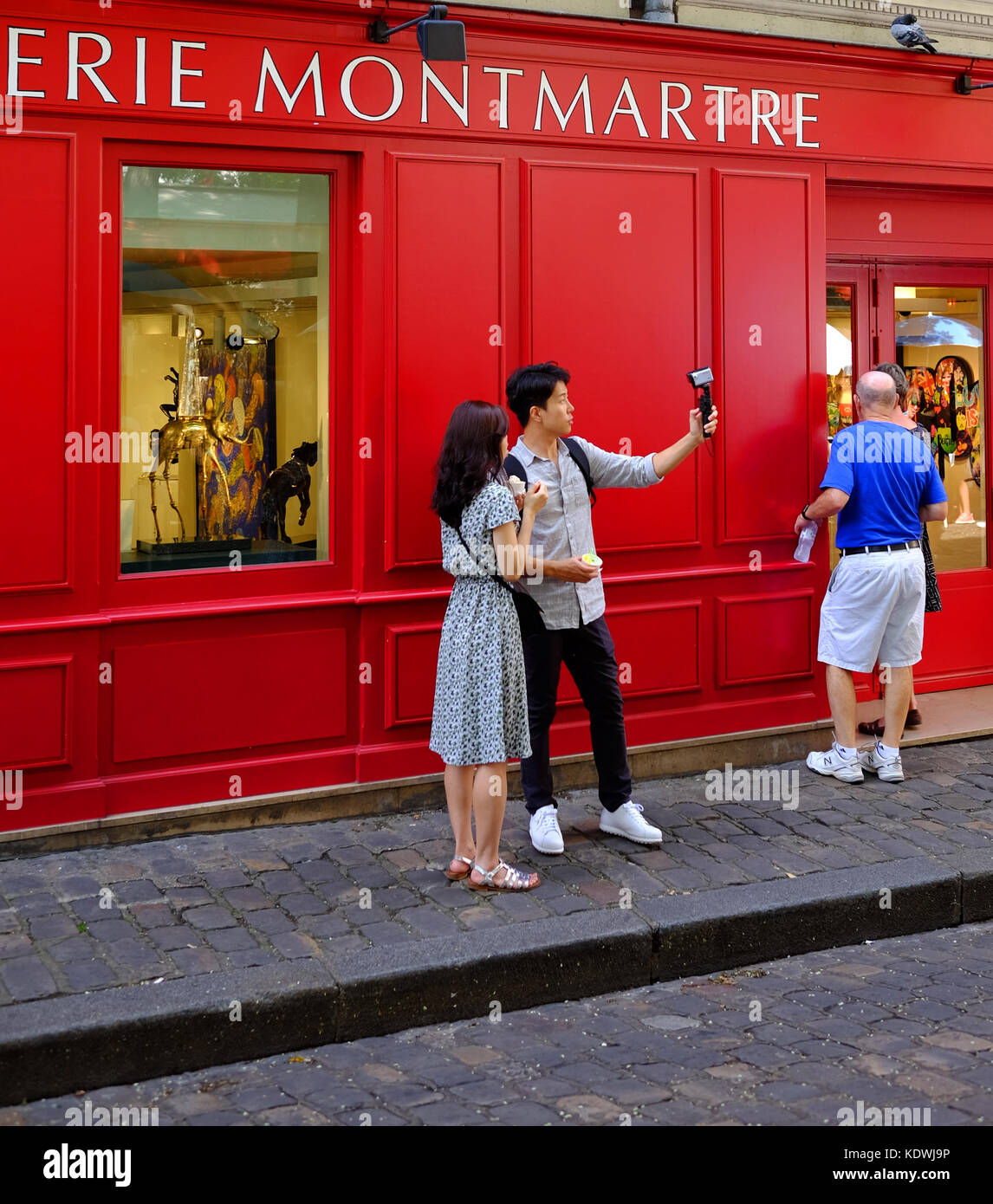 Un giovane turista giovane prendere un selfie o riprendere il video utilizzando la loro gopro camera in Montmartre, Parigi Foto Stock