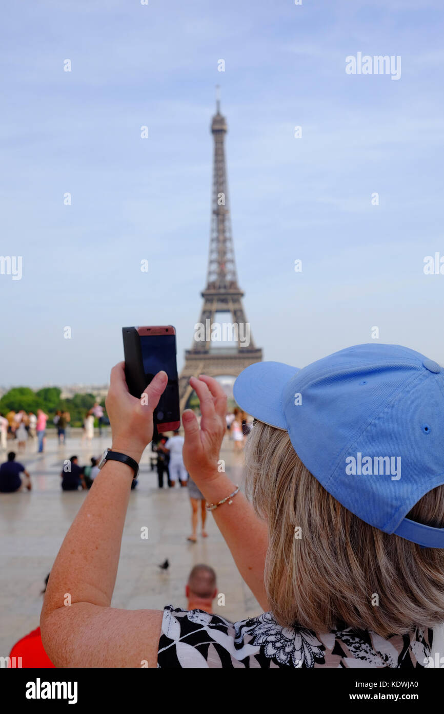 Un turista femminile prende una foto della Torre Eiffel a Parigi in una giornata d'estate Foto Stock