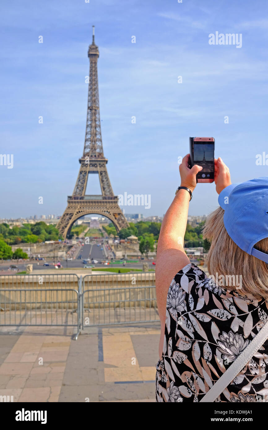 Un turista femminile prende una foto della Torre Eiffel a Parigi in una giornata d'estate Foto Stock