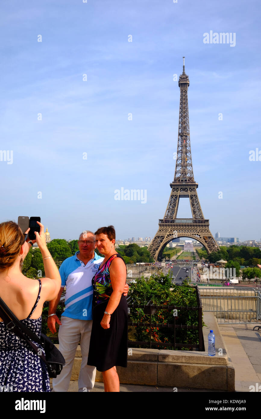 Una coppia matura hanno le loro foto scattata su uno smartphone di fronte alla Torre Eiffel a Parigi Foto Stock