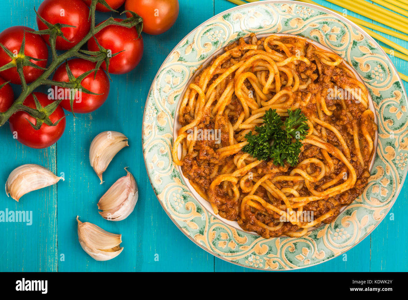 Stile italiano spaghetti alla bolognese pasto con una ricca salsa di carne su un blu sullo sfondo di legno Foto Stock