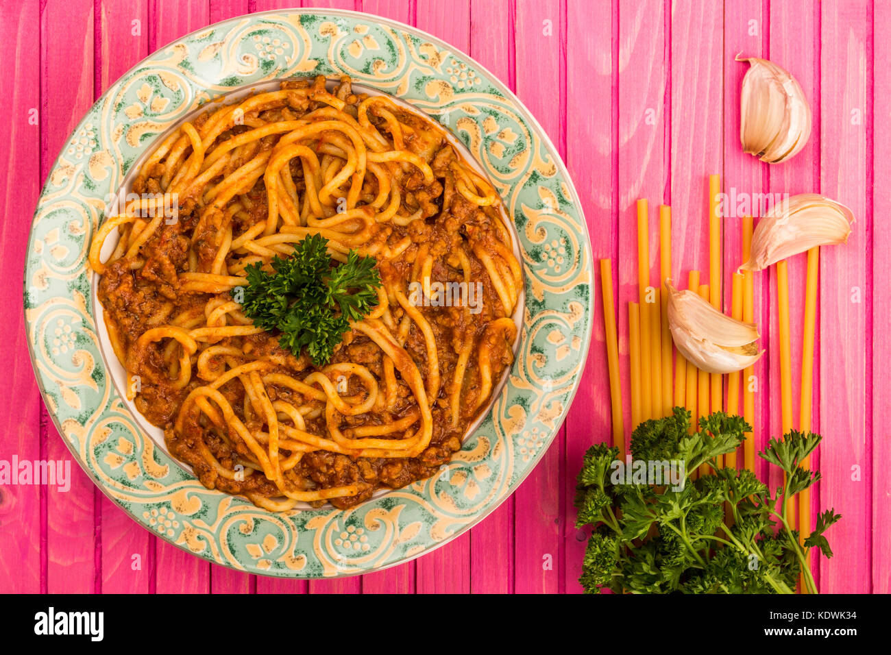 Stile italiano spaghetti alla bolognese pasto con una ricca salsa di carne su una rosa di sfondo di legno Foto Stock